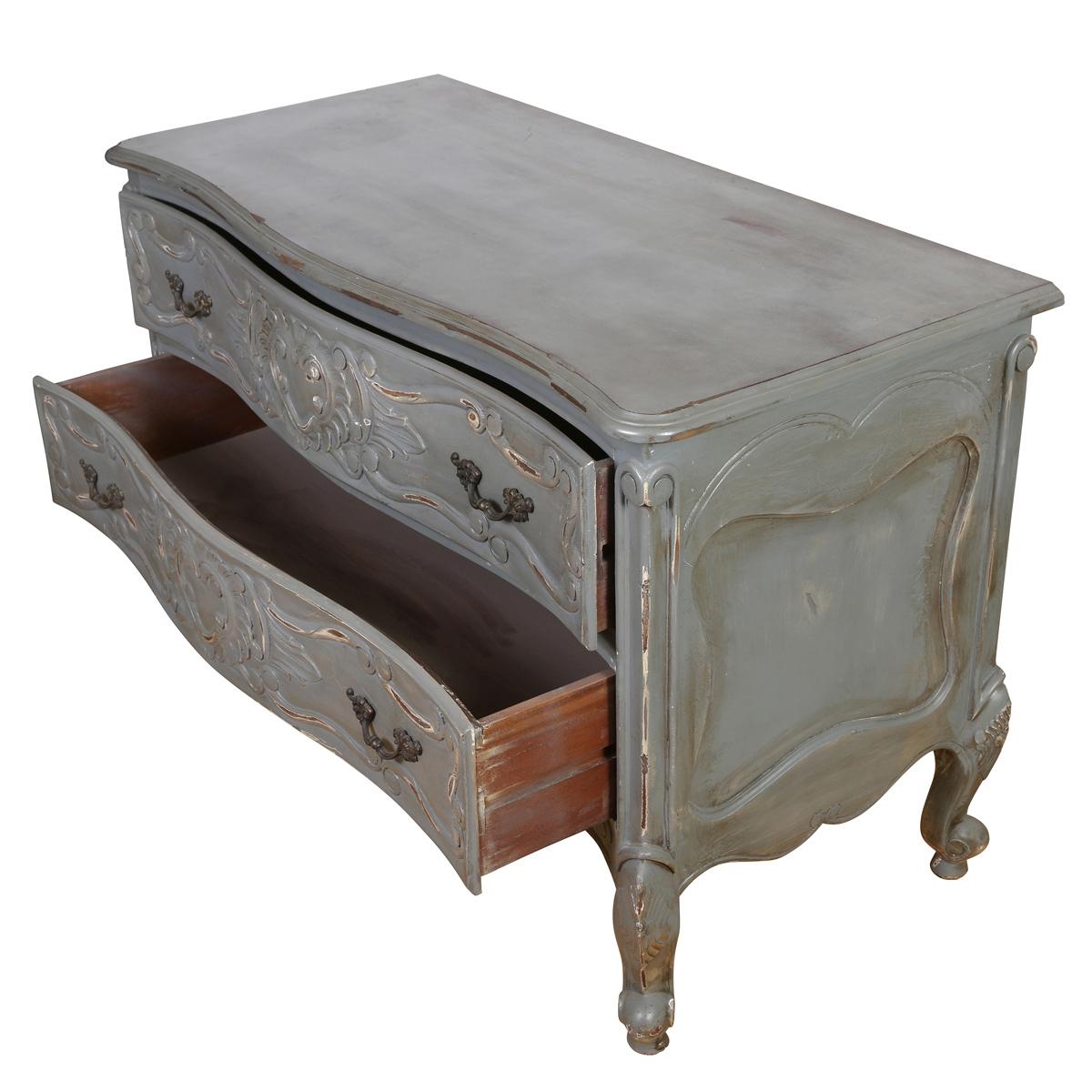 Ricca di fascino vintage e curve eleganti, questa cassettiera in stile provinciale francese dona un carattere senza tempo a qualsiasi spazio. Verniciato in un grigio tenue con una finitura delicatamente rovinata, il pezzo presenta due cassetti
