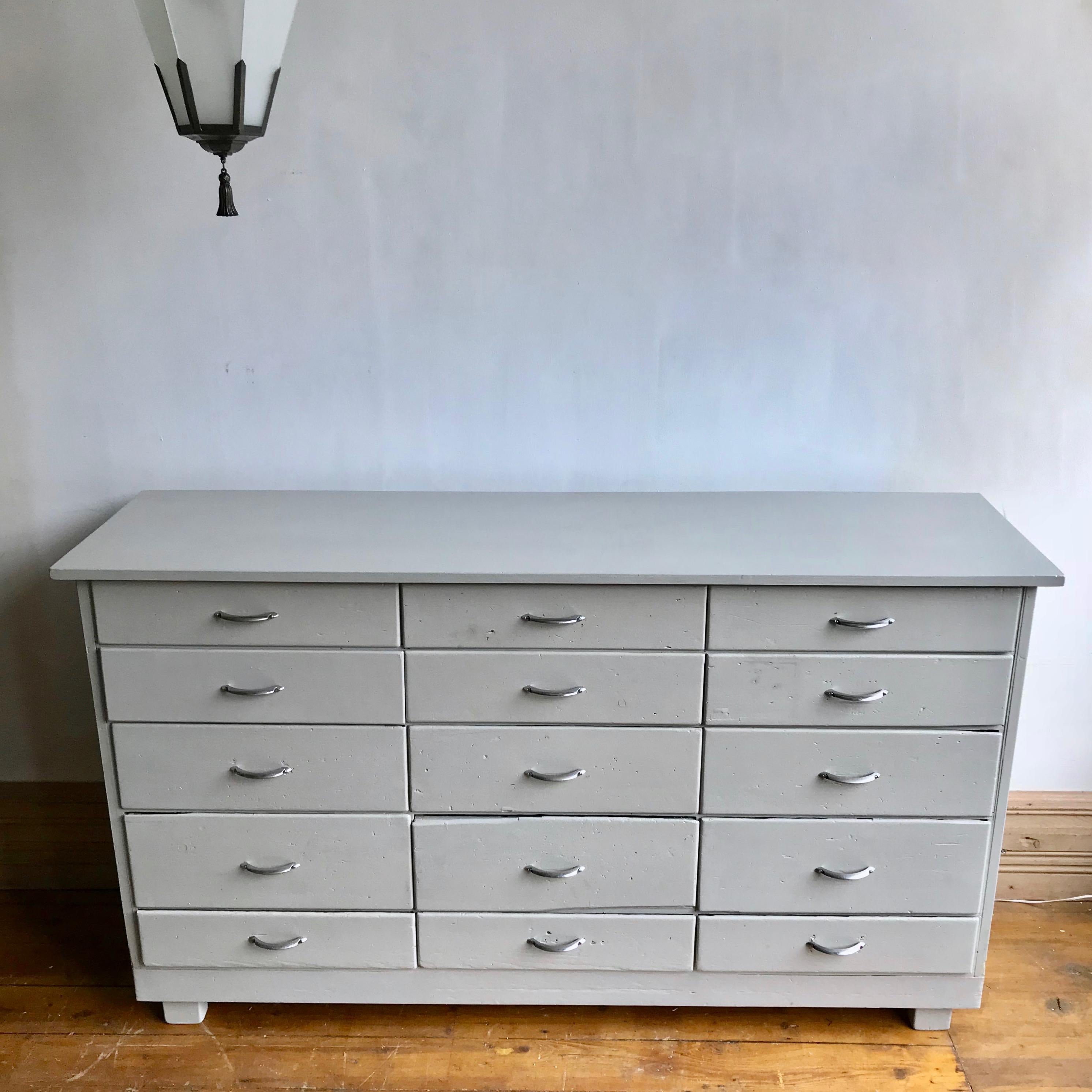 A 15-drawer bank of drawers painted in grey and then lacquered. With the original chromed midcentury handles.
   