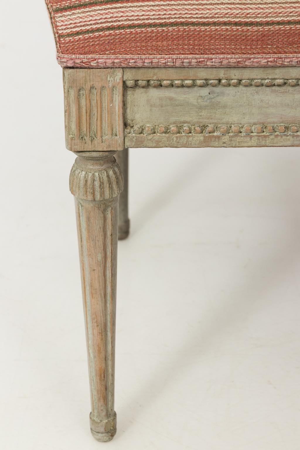 Late 19th century Gustavian white painted Provincial stool, featuring round fluted legs with carved details.
 