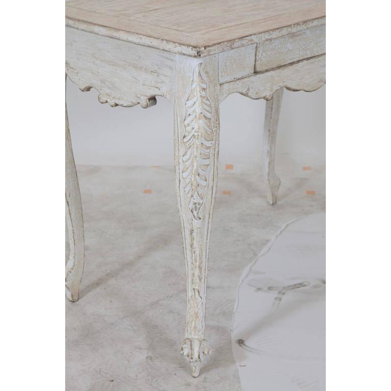 Hellweißer/grauer Gustavianischer Tisch mit einer Schublade und skulpturalen Beinen und Seiten.
Der Abstand vom Boden bis zur Unterseite der Schürze beträgt 23