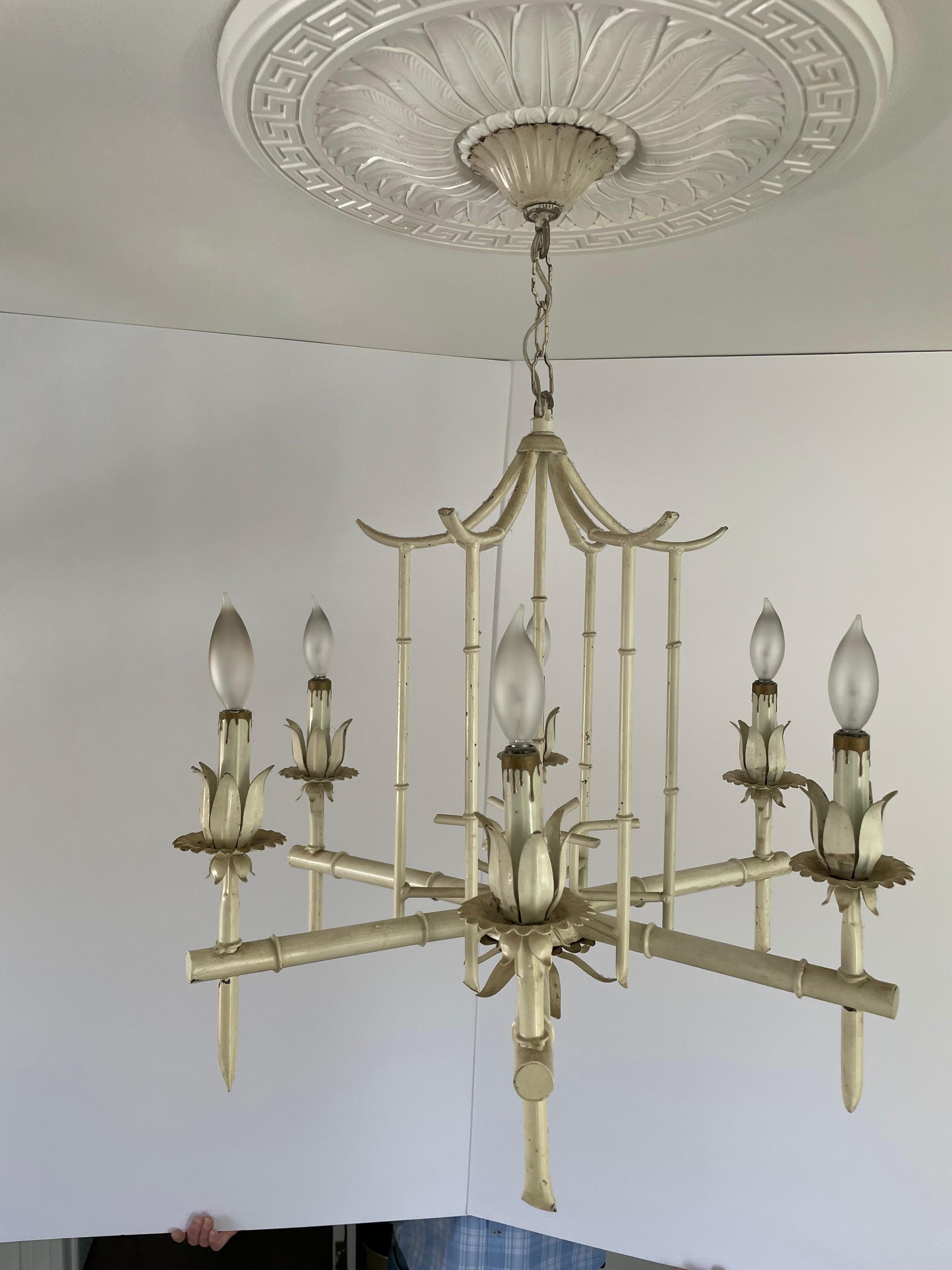 Painted Hollywood Regency faux bamboo pagoda chandelier from Italy. Six arms. Some chipping tp paint from age. Original ceiling cap included. Good working condition.