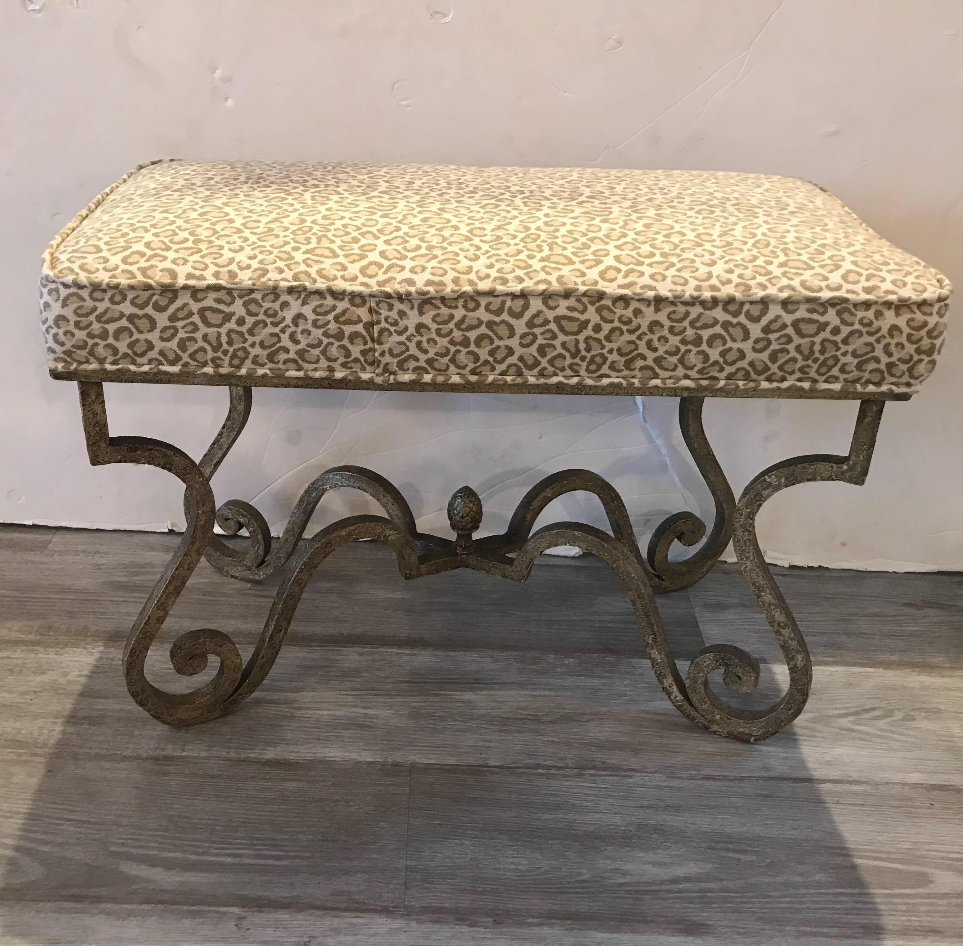 Chic upholstered bench with painted scrolled iron base topped with a neutral beige tone fax animal print fabric.