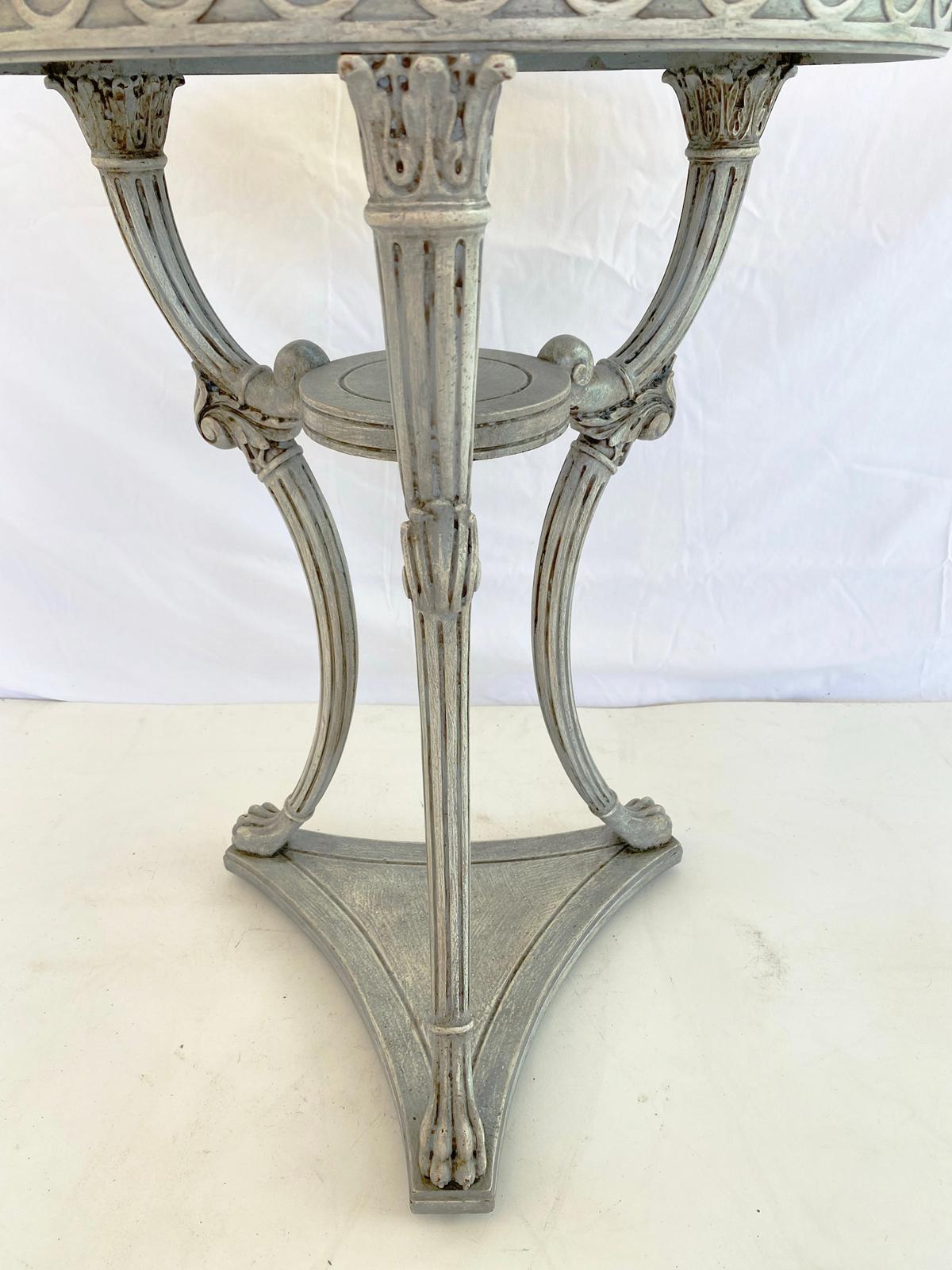 Unusual painted occasional table, having a round top with beaded border, on fielded apron outcarved with Vitruvian wave scrolls, raised on a trio of fluted horns, joined by a round shelf stretcher, set upon another three, foliate-headed, splayed