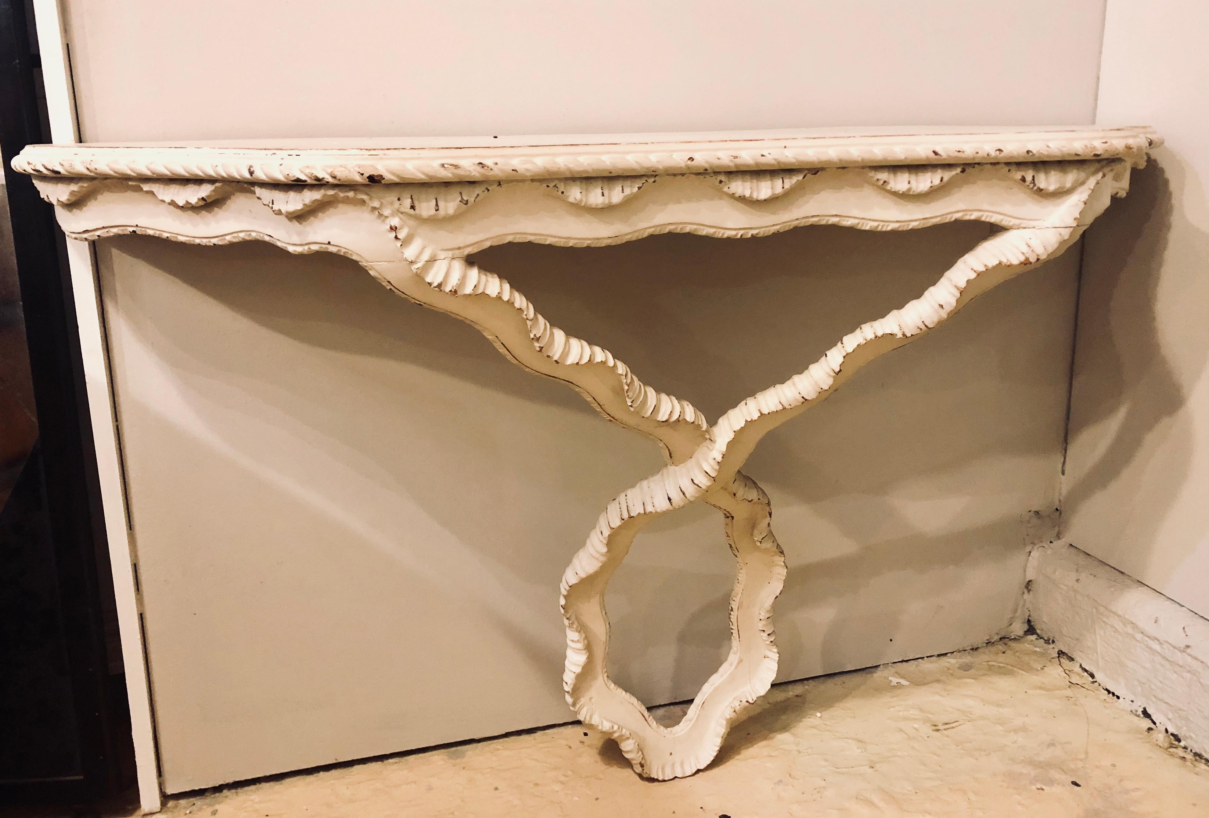 An painted Italian wall mount console with a ribbon form base. One screw and immediately you have one designer decorative wall. It is as easy as that with this fine Hollywood Regency console. Price well below the market it will not last long.