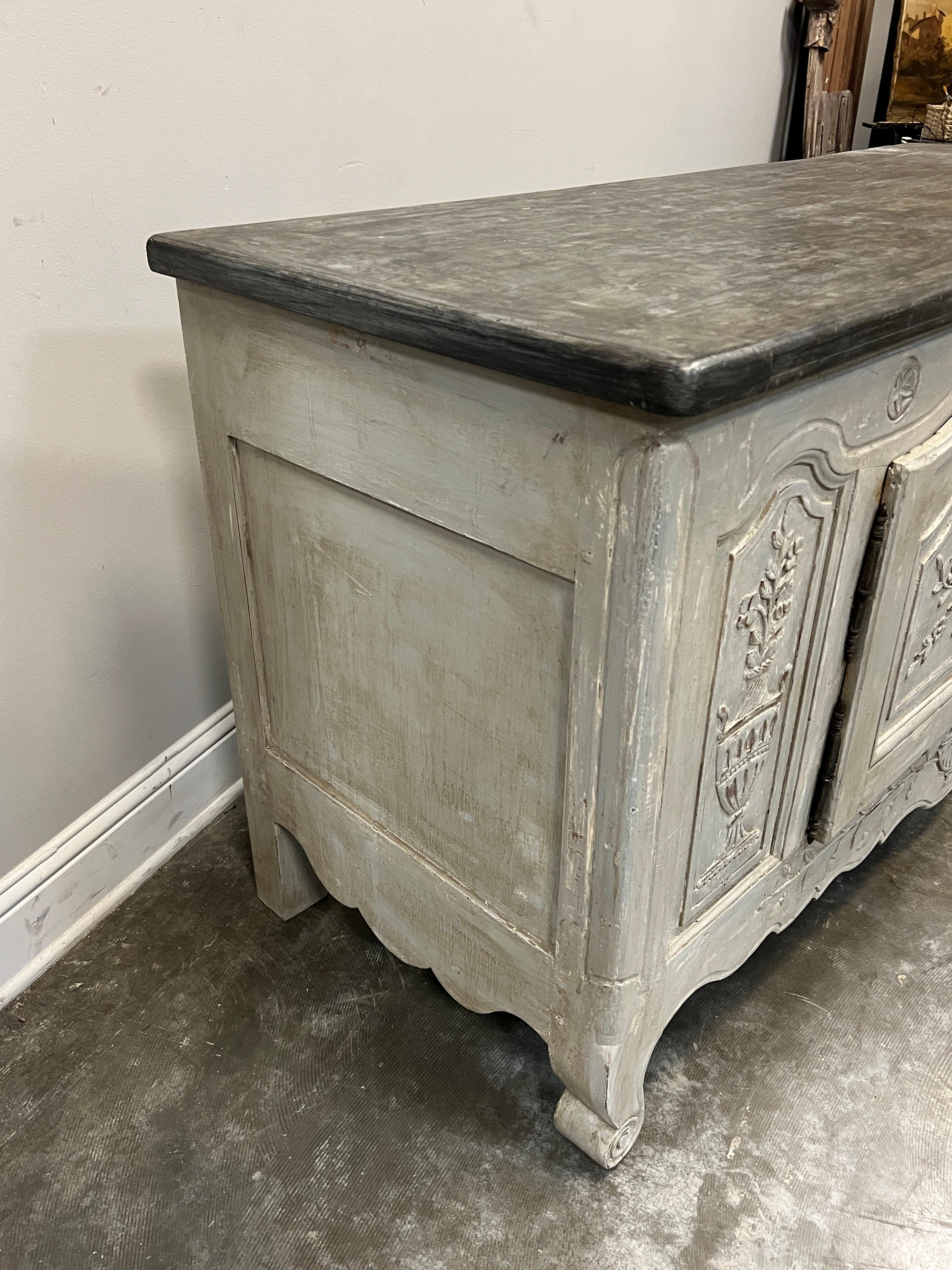 This buffet is a really charming painted Louis XV French Provincial buffet from the early 19th C. showing tool marks confirming its hand made origin. The buffet has an unusual placement of molded and beveled arched door panels with two center arched