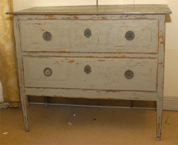 A two-drawer chest on tapered legs, this painted commode with original paint and hardware is from the period of Louis XVI.