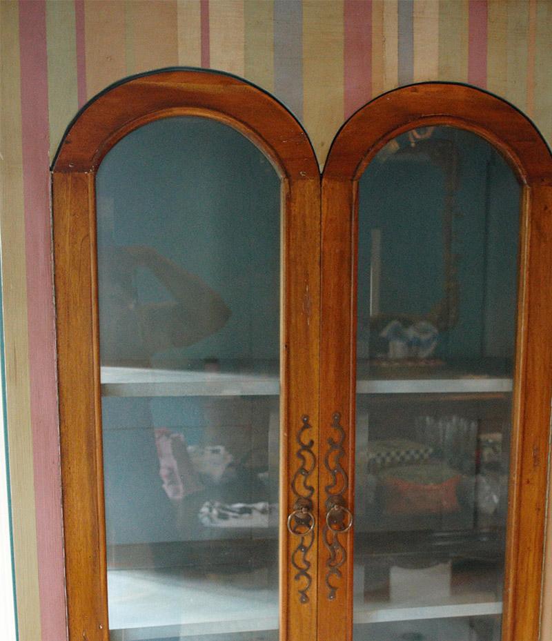Unique vintage solid mahogany curio cabinet. Whimsically hand painted in a multi pastel pallet of stripes. The large crown molding as well as the frames of the four arched top doors have been left in the natural wood color that accents the light