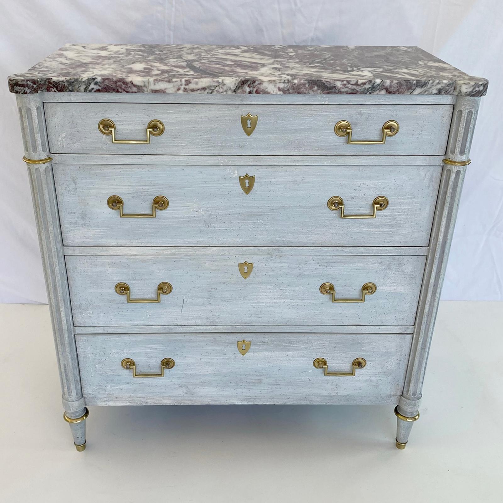 Narrow, Neoclassical style, painted hall chest, by Baker; having a painted finish, its rectangular top of rouge marble with rounded corners, on conforming base, its fluted stiles flank four stacked drawers, each with bracket handles, centered by