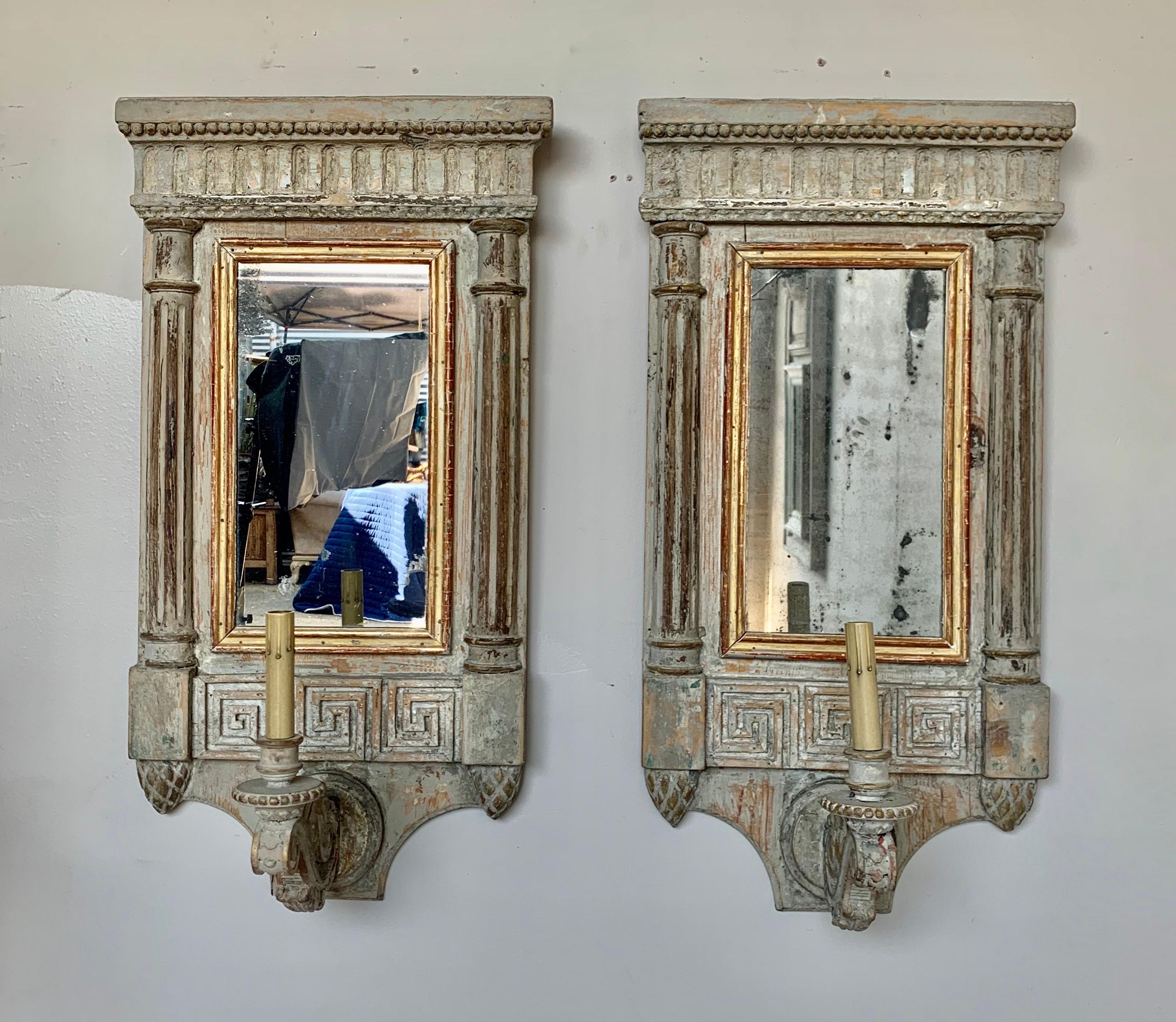 Pair of painted and parcel gilt carved wood mirrored sconces with Greek key design. The sconces have columns flanking either side of the mirror portion.