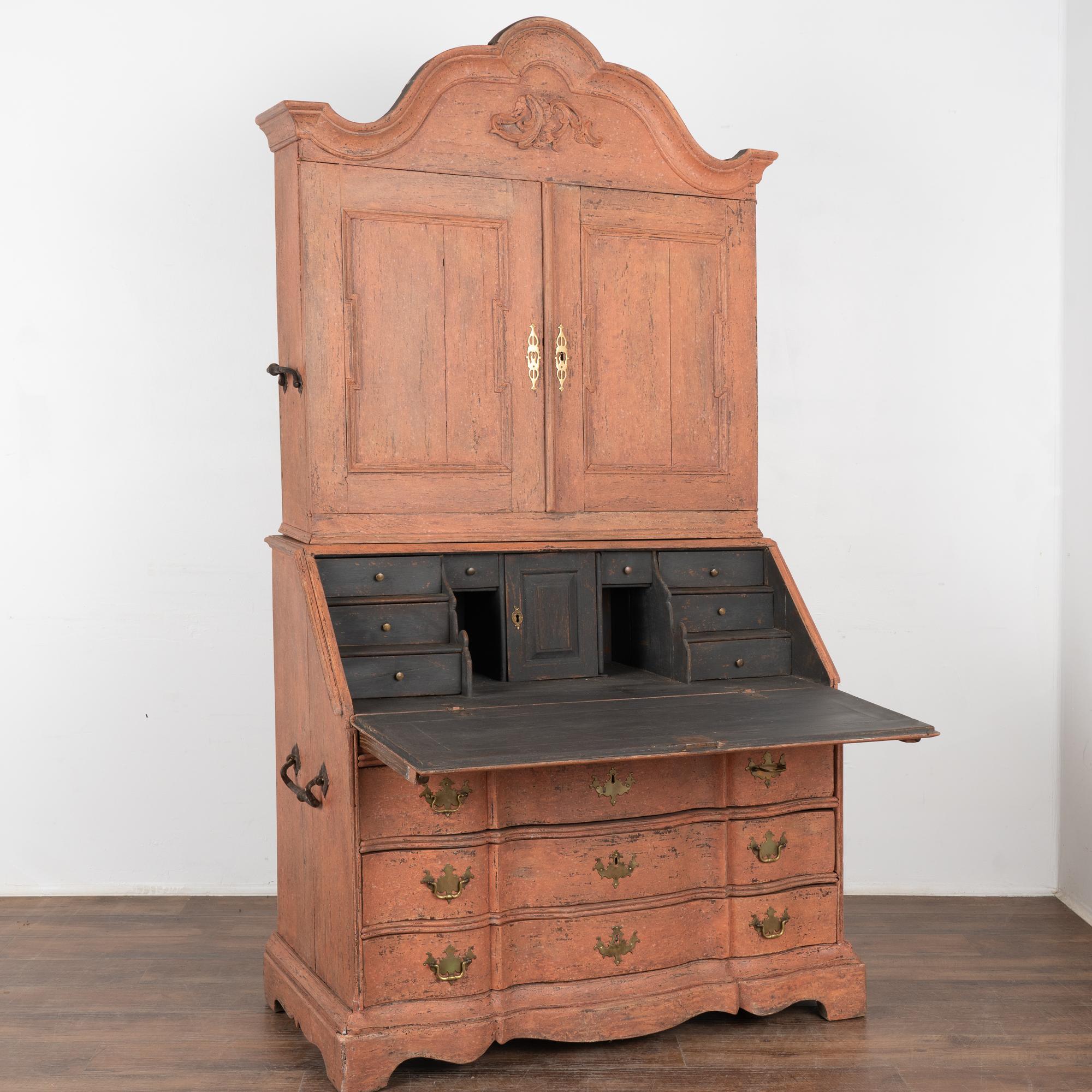 This striking oak secretary is an elegant statement piece crowned with a beautifully curved and carved bonnet or crown.
The entire secretary has been given a professional custom layered salmon/desert pink painted finish which has been gently