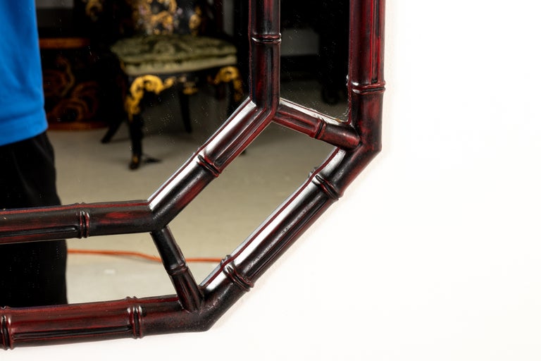 Octagon faux bamboo mirror with painted reddish black finish.