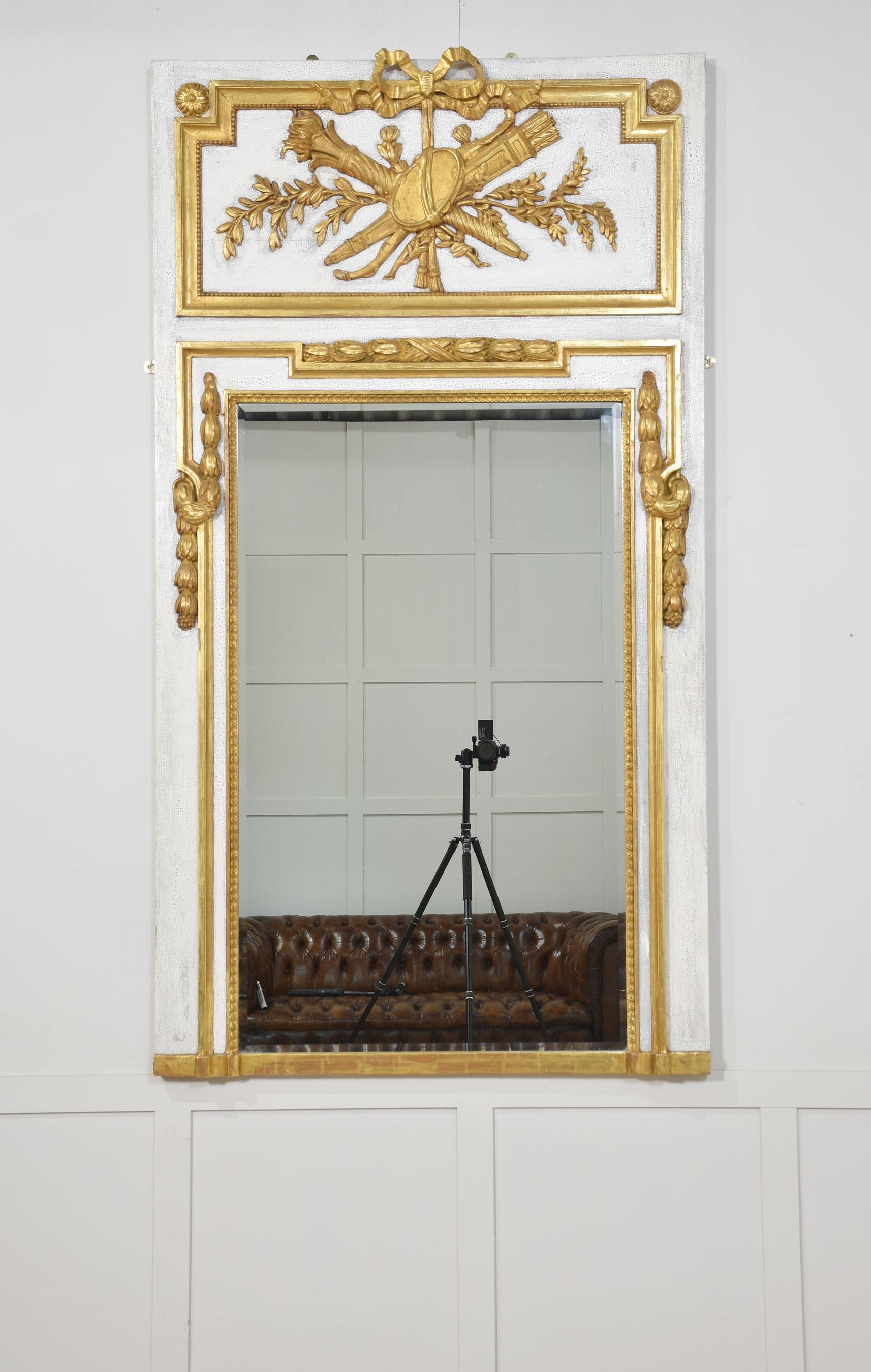 Specchio da parete dipinto di bianco con torcia fiammeggiante intagliata e decorazione in legno dorato a faretra, sopra la lastra originale dello specchio smussata e racchiusa da un bordo in legno dorato.
Dimensioni
Altezza 79 pollici
Larghezza 43