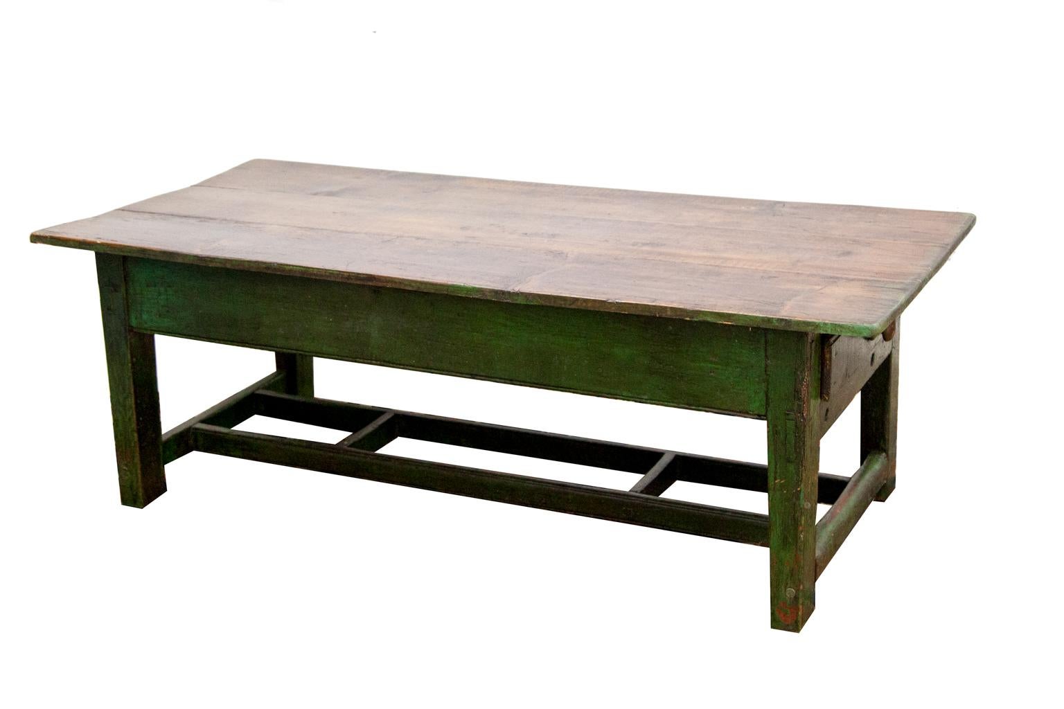 Painted pine coffee table, with one drawer at the end and a double-H stretcher below. The base is painted forest green, the top is scrubbed pine with green on the edges.