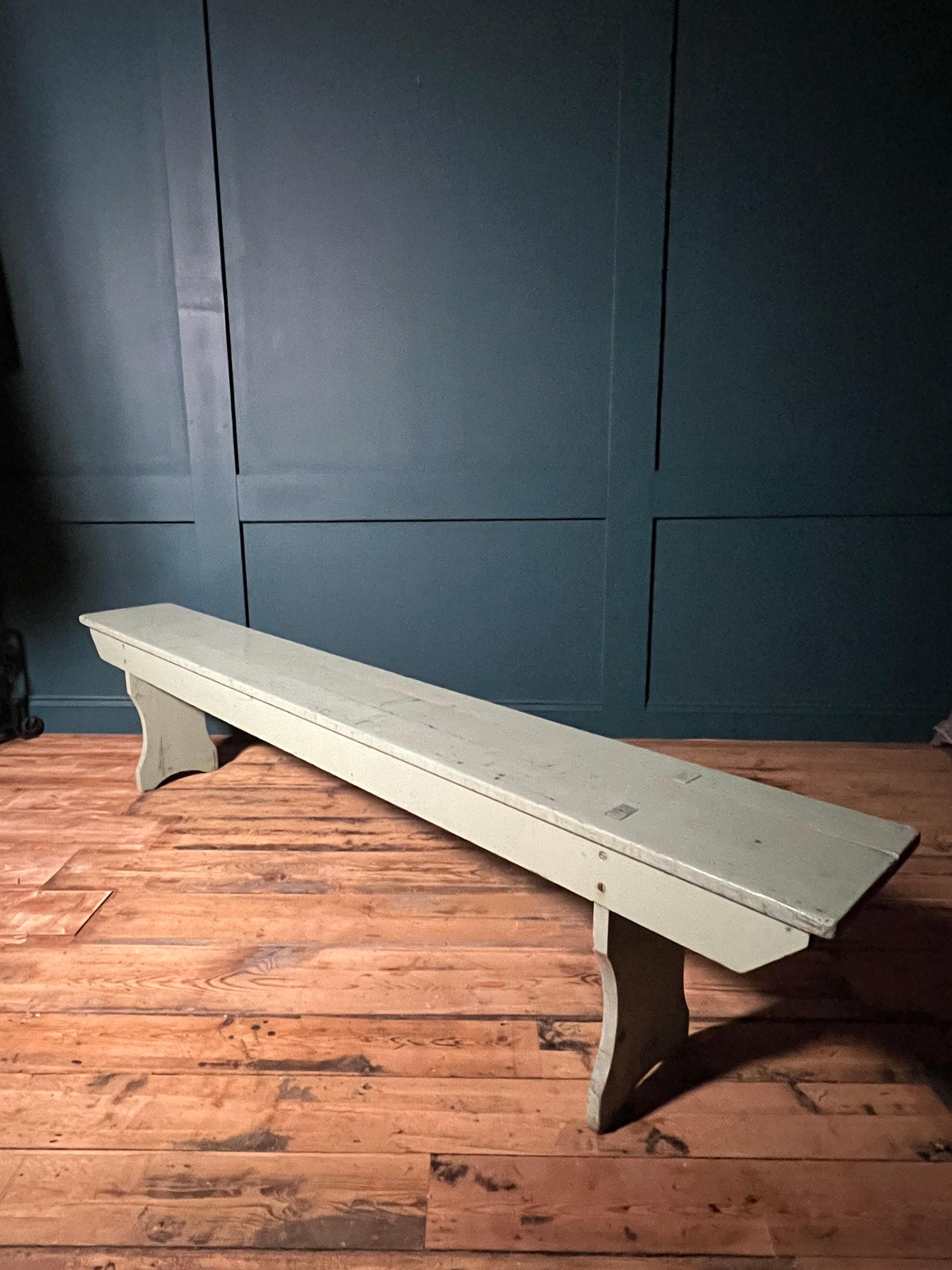 This charming painted Pine French Farmhouse long bench from the 1930's is a beautiful addition to any home. Made from sturdy pine wood, this bench exudes rustic charm with its distressed, pastel green painted finish. The long, narrow design is
