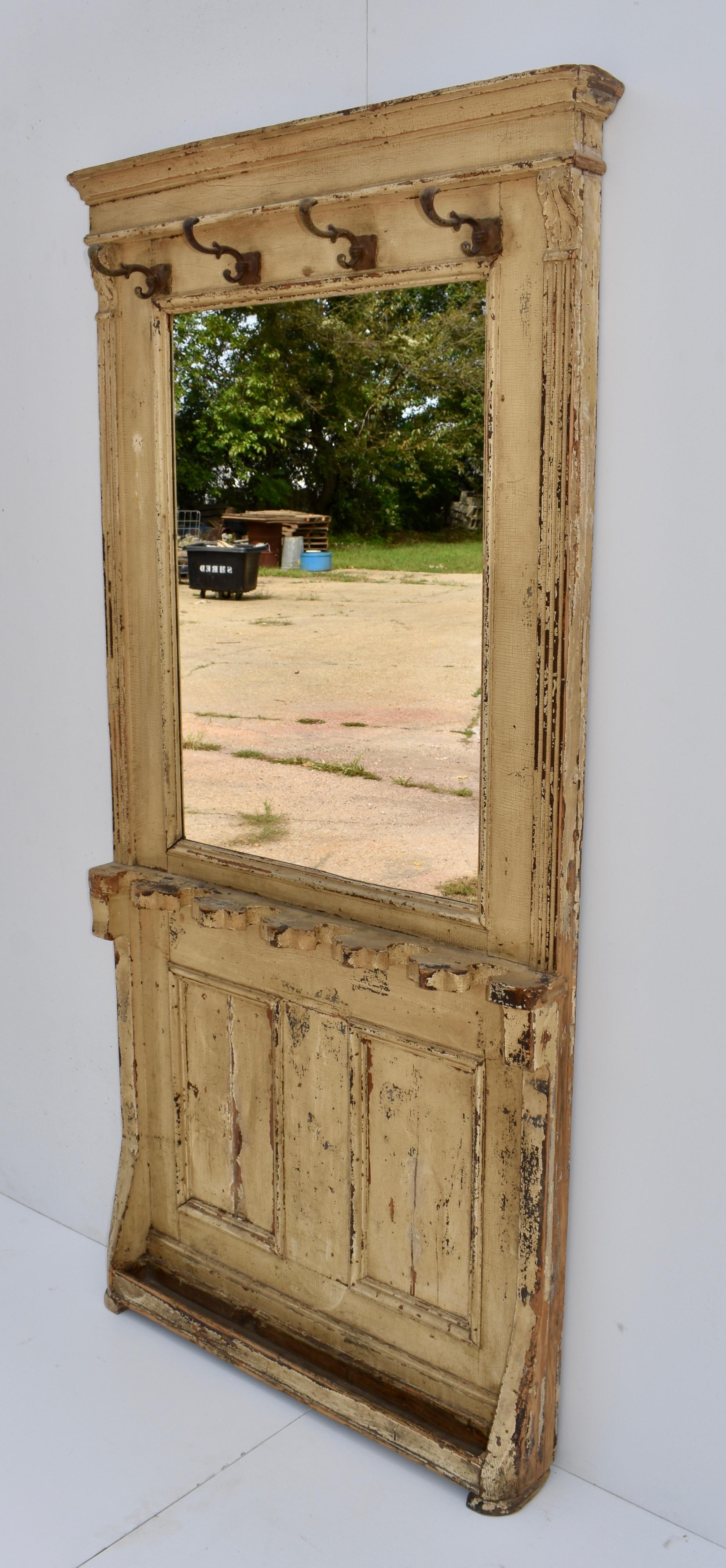 This wonderfully shabby pine hallstand has four original coat hooks above a large mirror and two flat panels behind six wooden holders and a drip tray (zinc liner sadly missing) for storing walking sticks or umbrellas. The front corners are