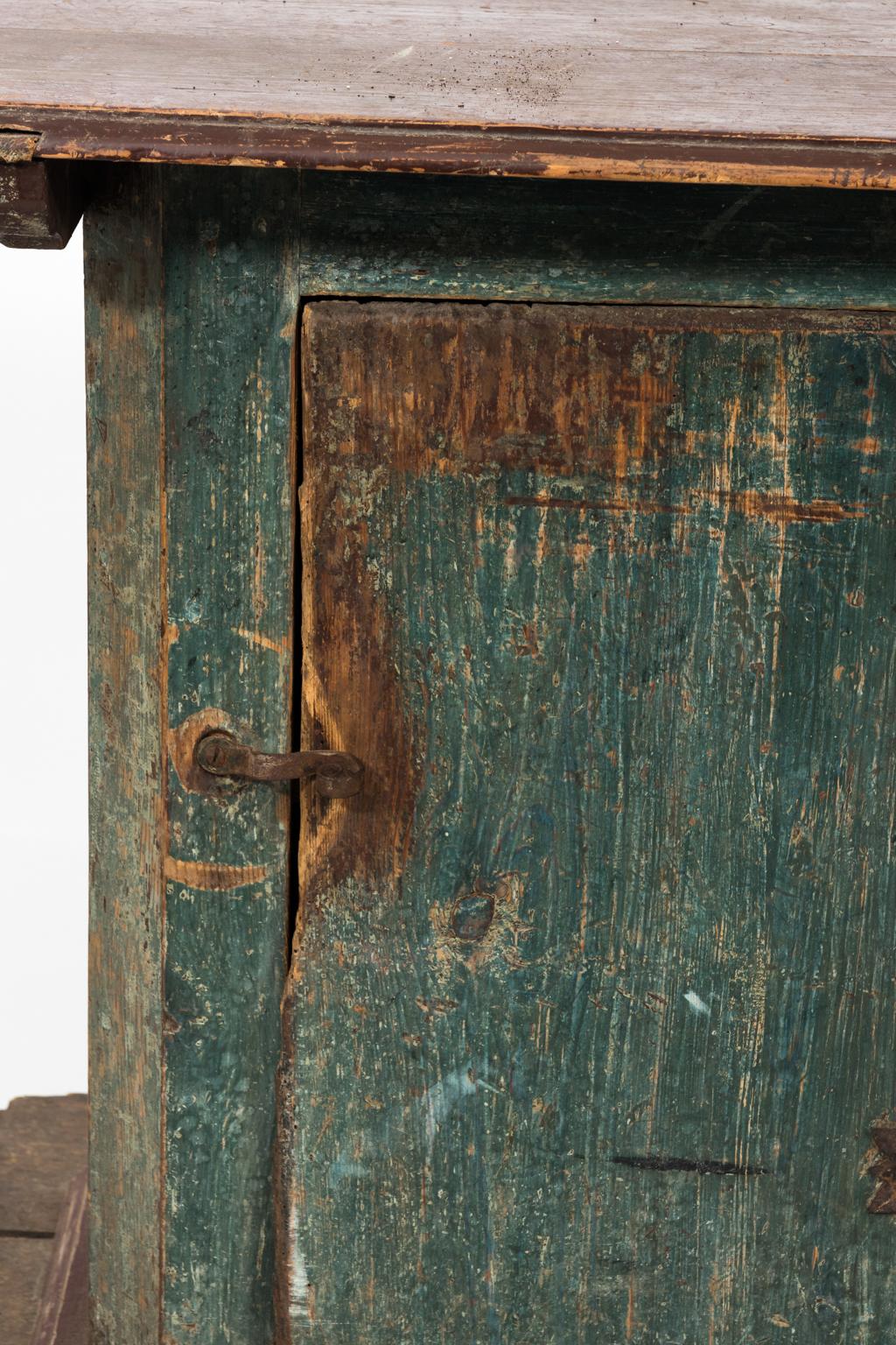 Painted pinewood pedestal cabinet with one door and metal hardware in original weathered finish, circa 1900s.