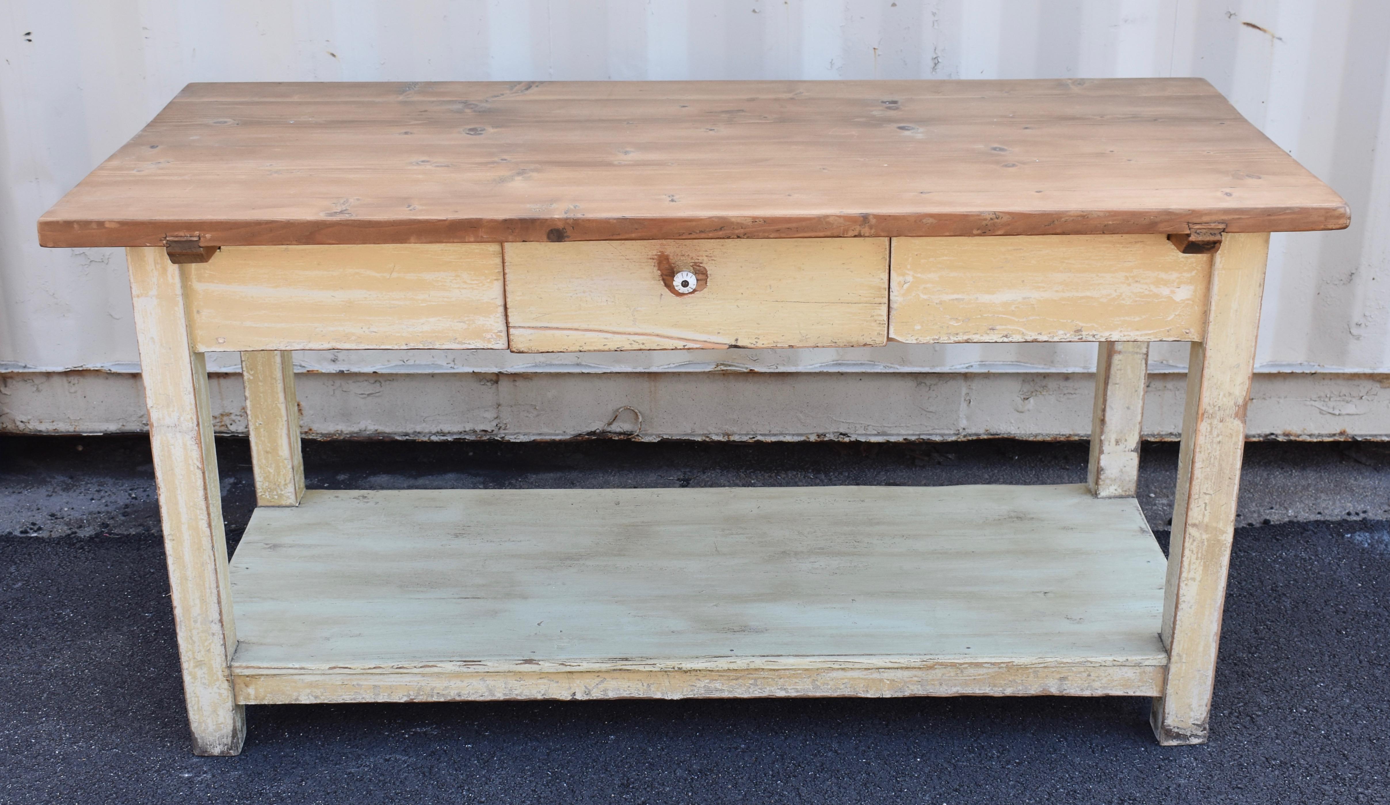 The top of this sturdy and versatile work table is almost 1.5” thick. Two cleats are dovetailed into the underside and slotted into the upper corners of the base. The base itself has deep aprons with a single handcut dovetailed drawer in the center.