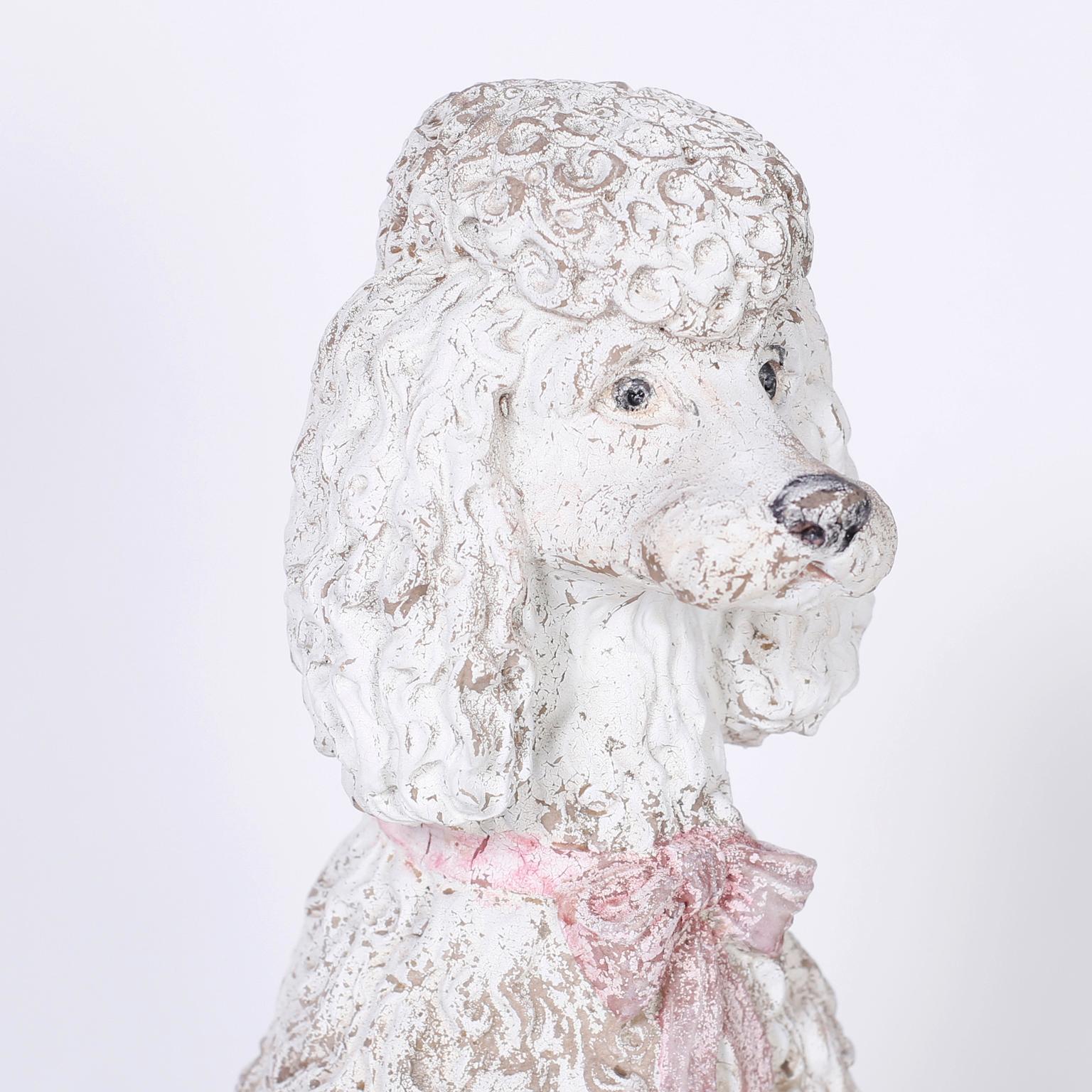 Cast composition poodle statue with paint now worn to perfection, sitting on a decorated base with draping and tassels.