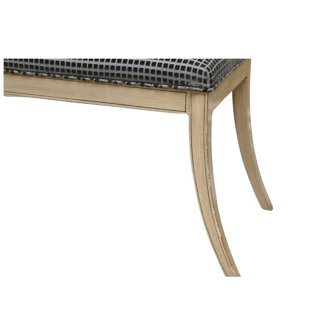 Banc de style Régence en bois peint et tapissé, avec des pieds en sabre.  Le revêtement personnalisé est un tissu bleu géométrique ton sur ton avec un motif carré floqué. 