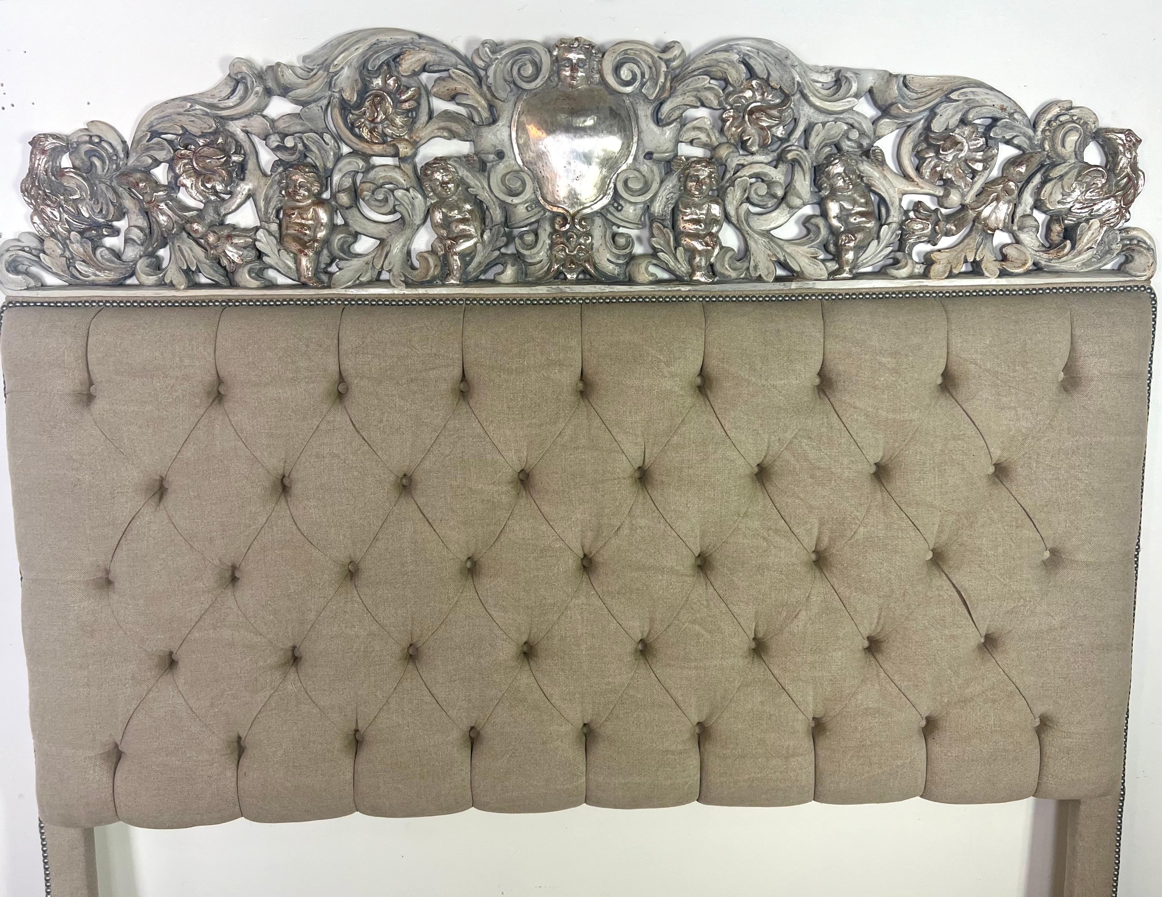 This custom headboard is incredibly exquisite and rich in detail.  The use of an Italian carved, painted, and silver-gilt panel as the main feature adds a remarkable historical and artistic value.  The panel is upholstered into the headboard with