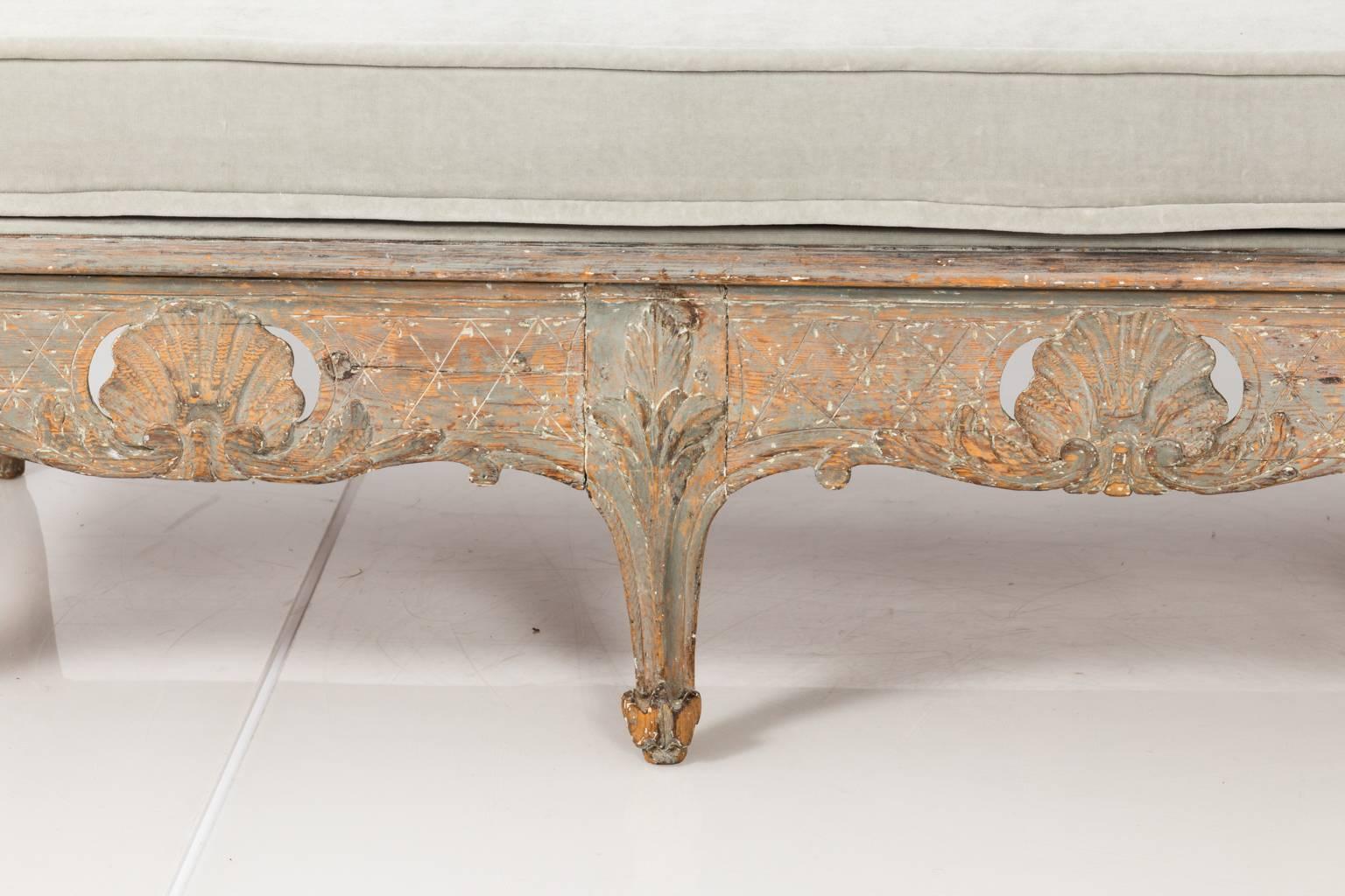 Swedish painted bench re-upholstered in dove grey velvet with a decoratively carved shell work seat rail, circa 1770.
 