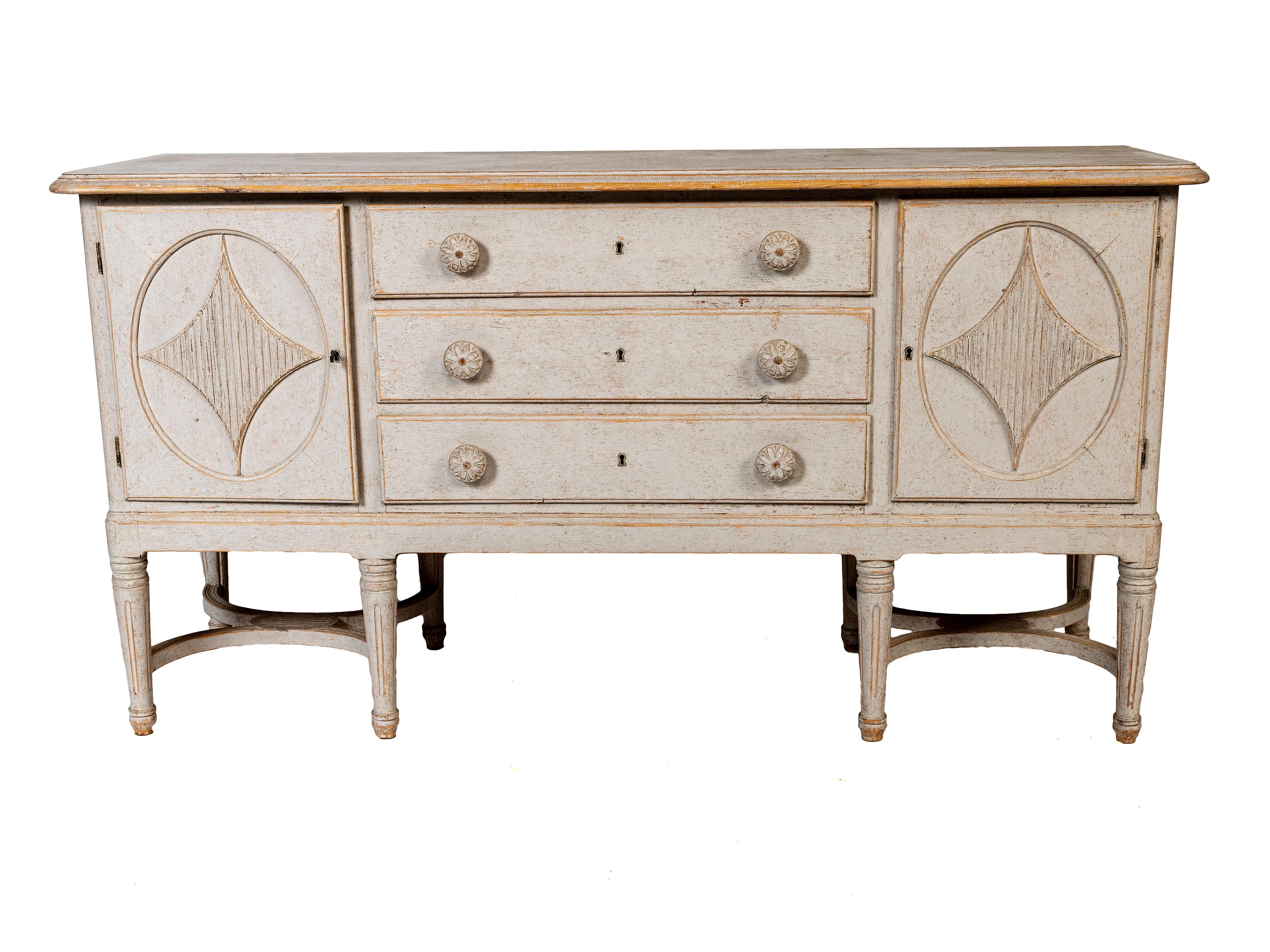 A Swedish Gustavian pine sideboard server with traditional carved fluted diamond panel motif on both of the two doors.  Tapered fluted feet.

This Swedish Gustavian style sideboard, dating back to circa 1880, is a splendid example of classic