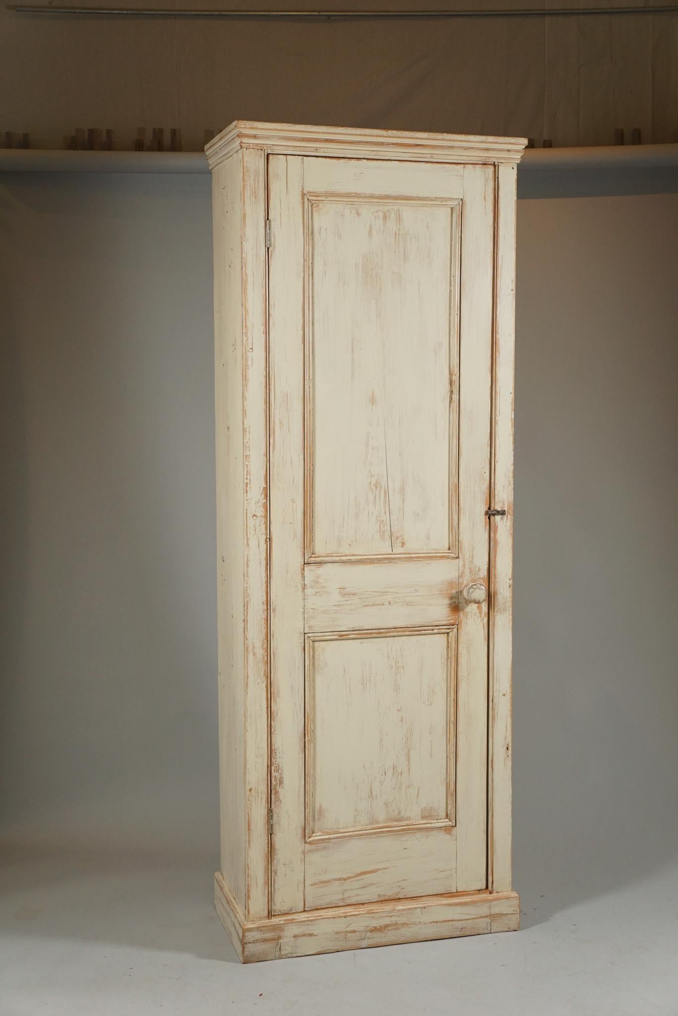 Painted country cupboard is off-white finish. Narrow and tall cabinet.