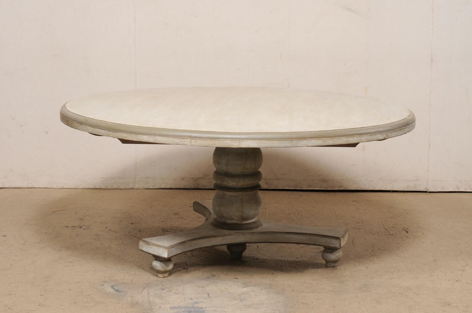 A vintage painted teak wood round pedestal dining table. This dining table from India features a round-shaped top (2.75