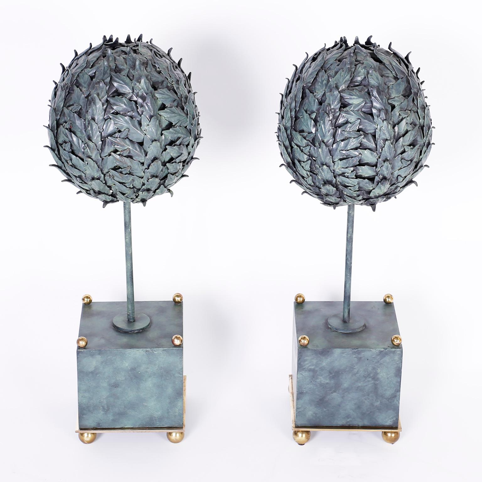 Midcentury tole or painted metal topiaries depicting round trimmed trees in square planters with brass ball finials and feet. Signed Maitland-Smith on the bottom.