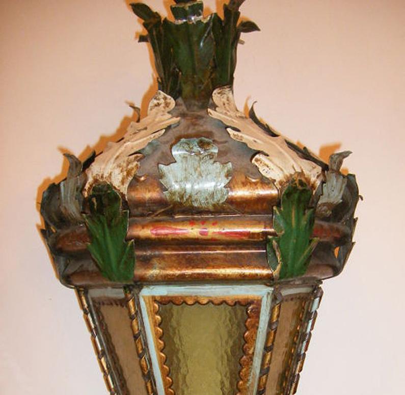 A circa 1920's painted and gilt tole Venetian lantern with glass panels and original patina.

Measurements:
Min Drop: 22