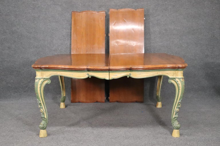 This is a charming French country dining table. The table has a natural walnut top and some fine paint work on the base. There are two leaves each measuring 20 inches for a total possible length of 106 inches long x 55 wide x 30 tall.