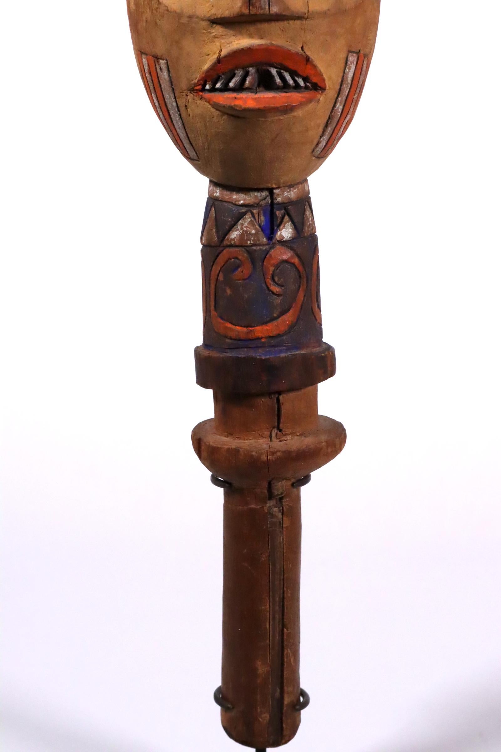 Puppet head, painted wood, Kuyu people, Republic of Congo, Africa. Created in the early to mid-20th century.
17 x 4 3/4 x 5 inches. With a detachable custom metal stand that raises it to 18 1/2 inches.
This puppet portrays a stylized human head