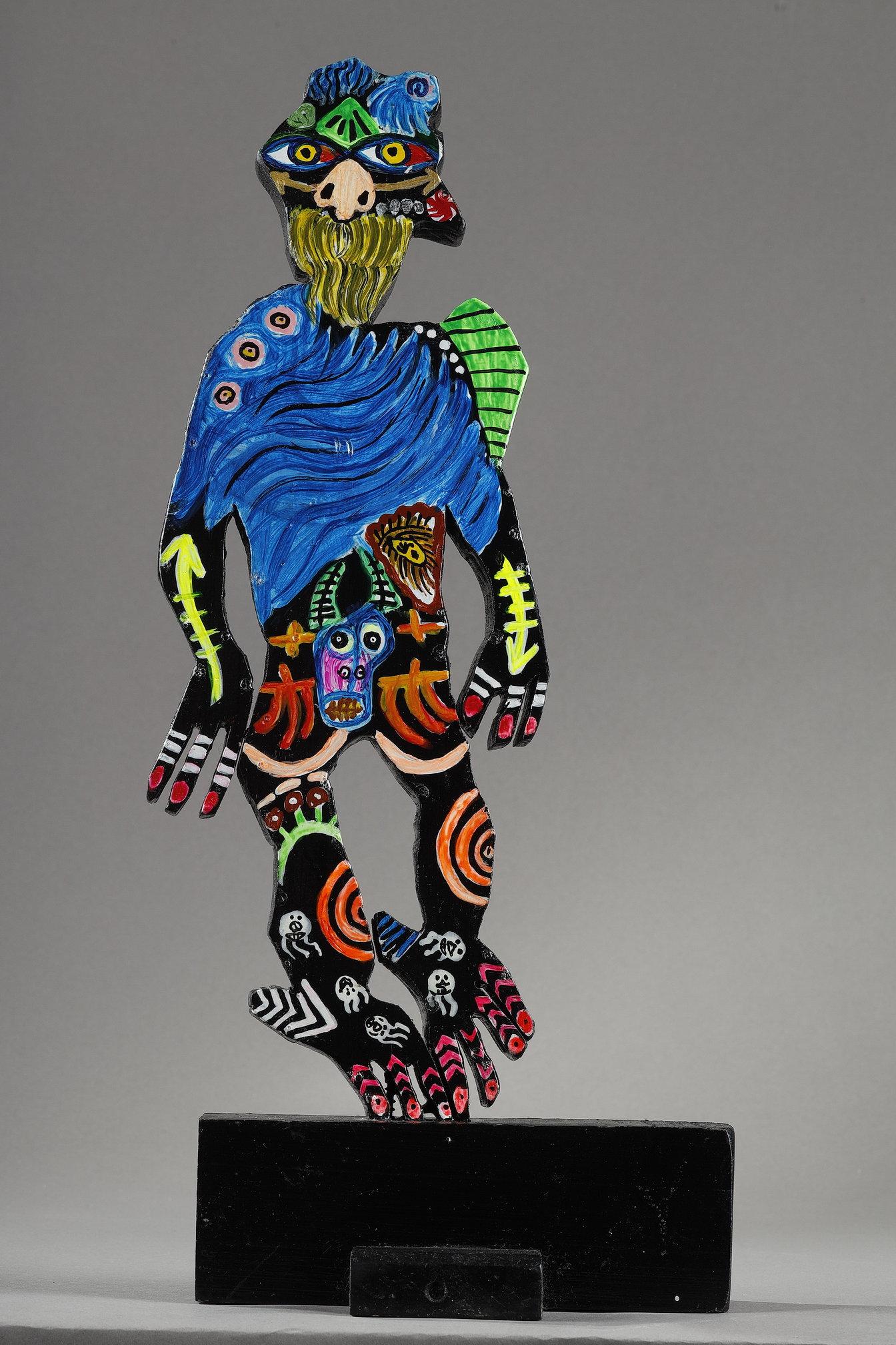 Scultura in legno dipinto dell'artista Mohammad Ariyaei. Il Djinn è scolpito nel legno e poi dipinto su due lati distinti, ognuno dei quali fornisce un'interpretazione artistica unica:
- Sul primo lato, la scultura è dipinta in modo vivace ed