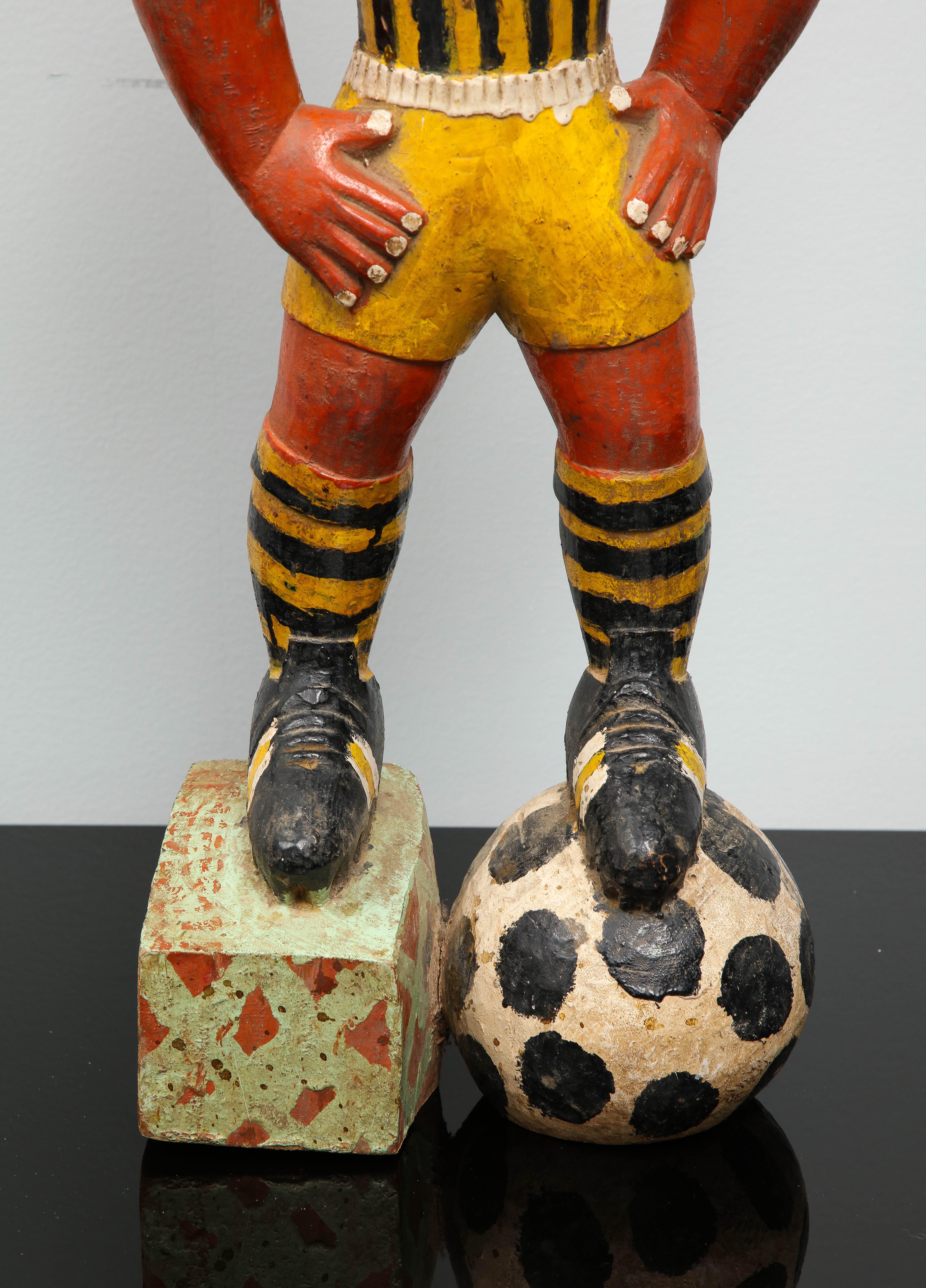 African Painted wood sculpture of a soccer player