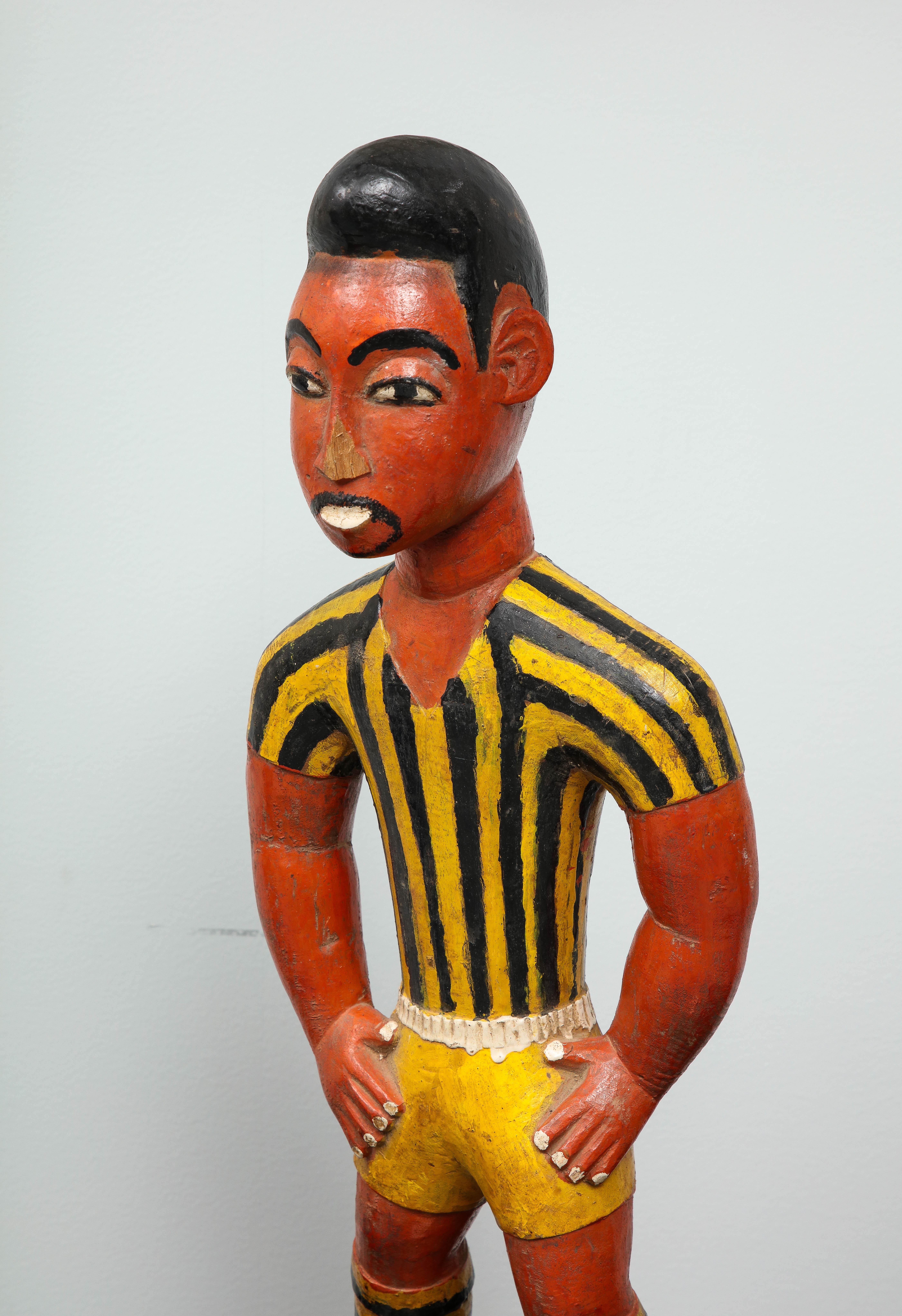 Wood Painted wood sculpture of a soccer player