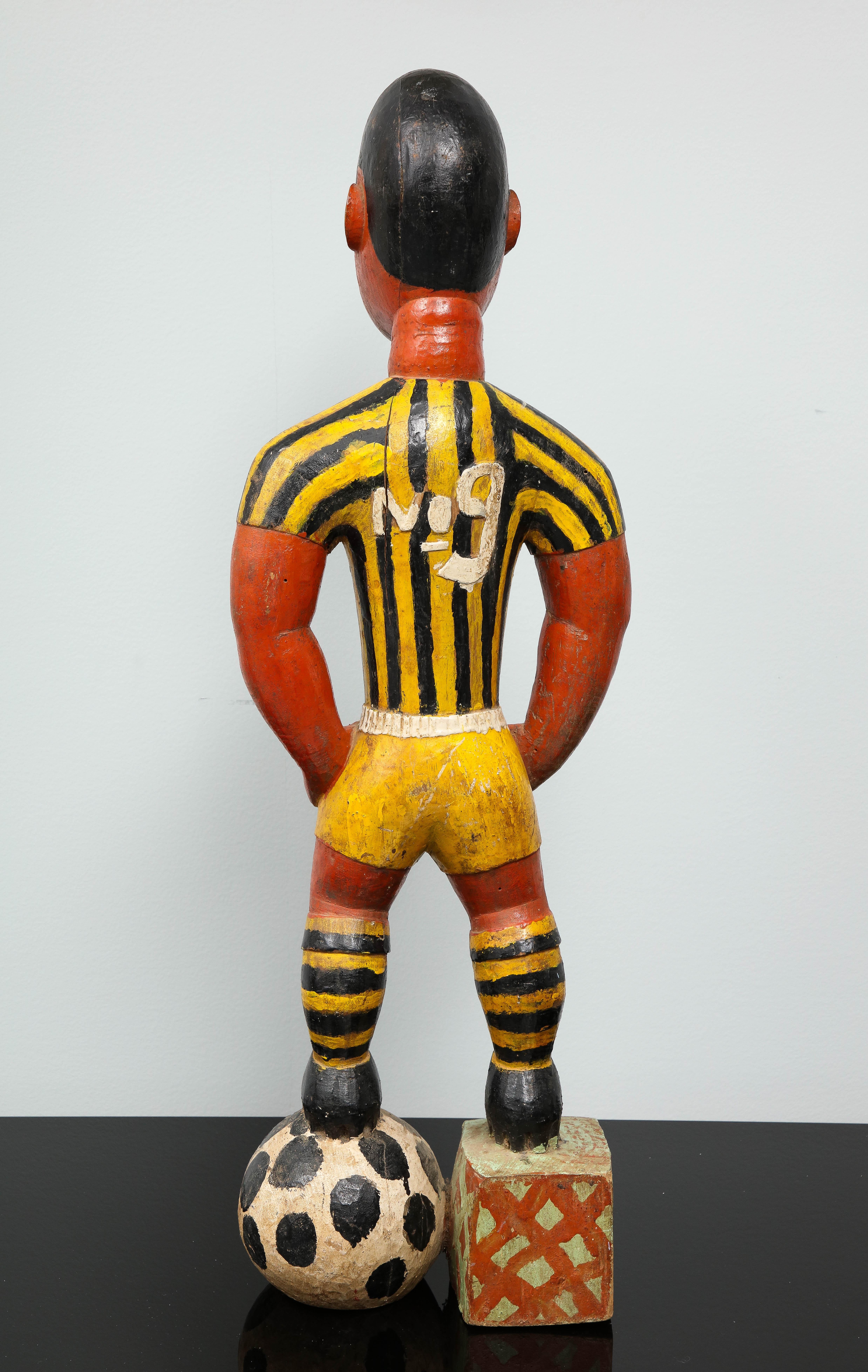Painted wood sculpture of a soccer player 2