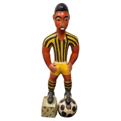 Painted wood sculpture of a soccer player