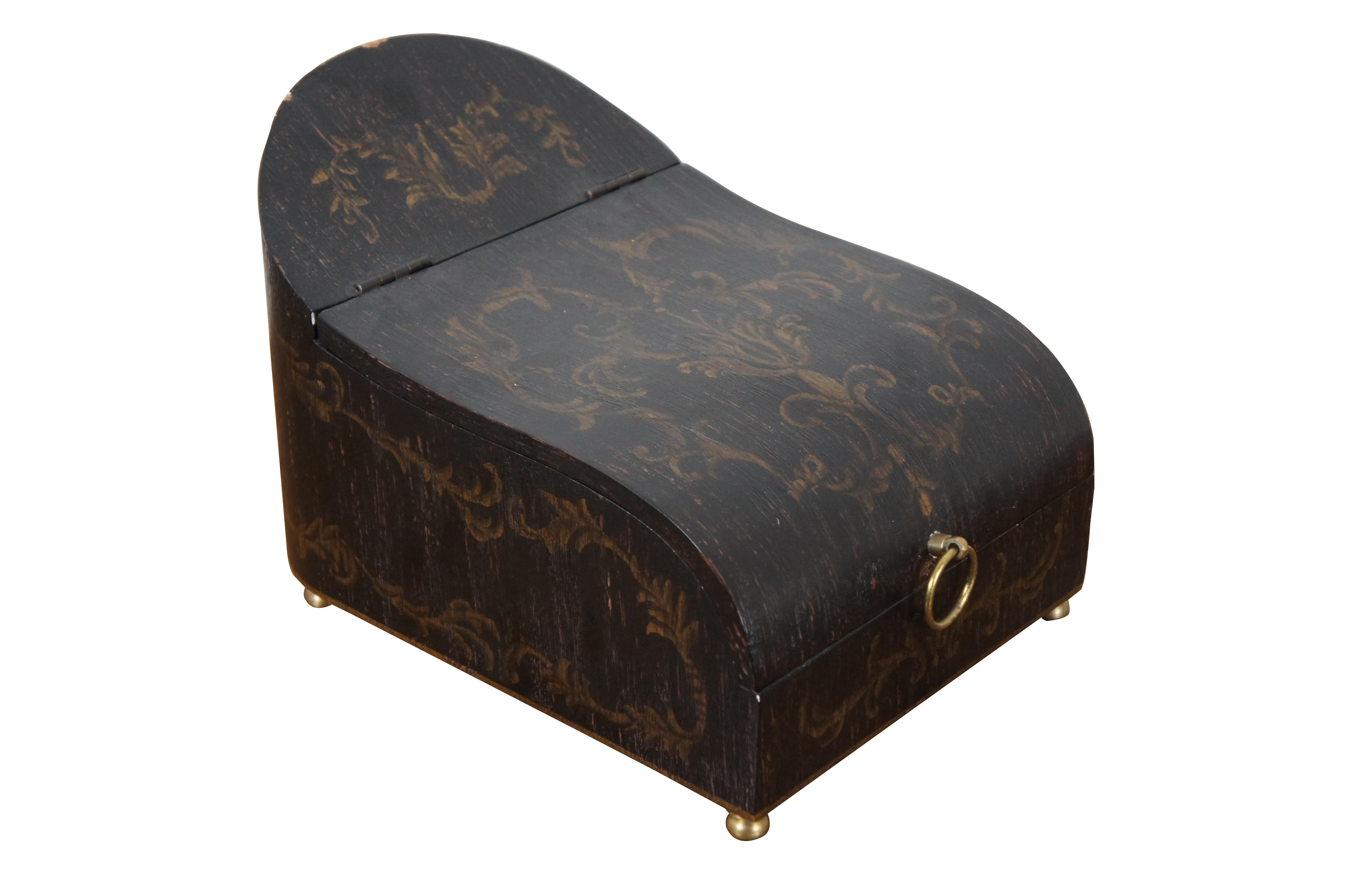 Vintage sleigh shaped wooden keepsake / stationary box painted black with golden stenciled French foliate designs, with a antiqued / distressed finish, gold bun feet, and brass ring handle at the front.

Dimensions:
8.75” x 12.25” x 8.25” (Width x