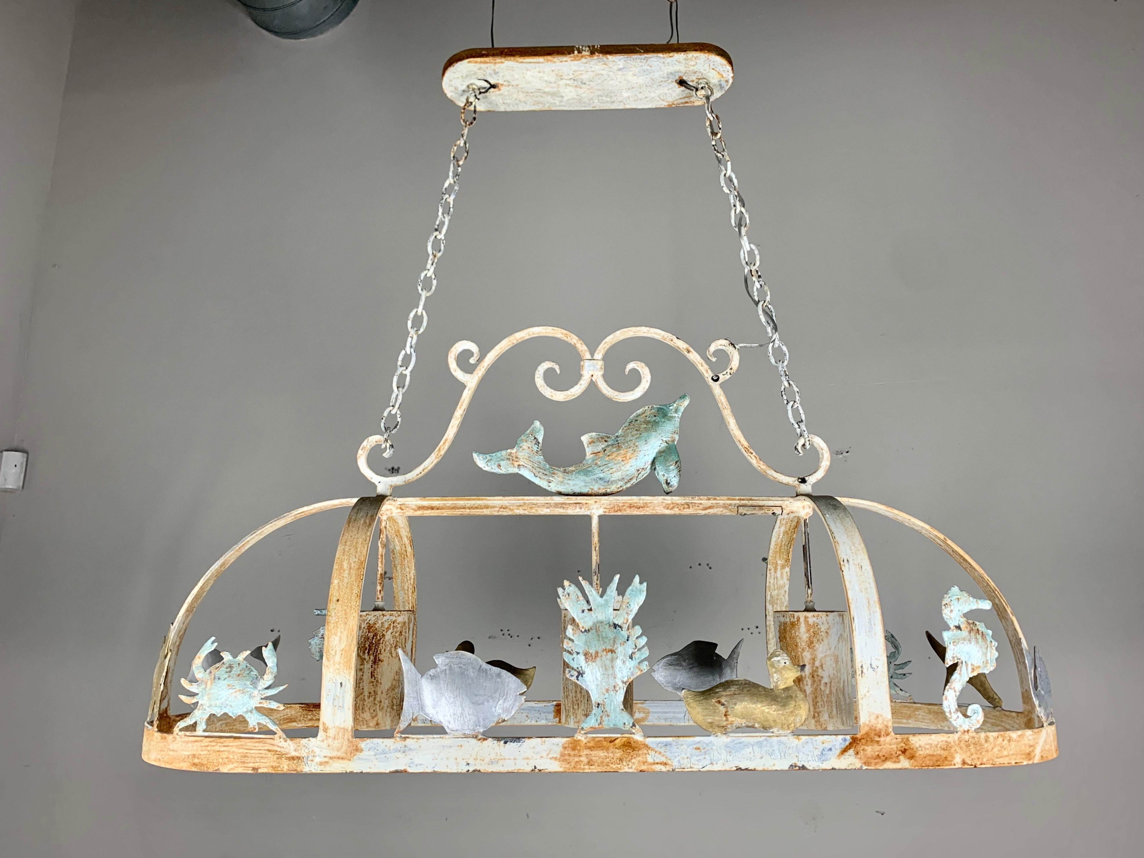 Unique wrought iron painted pot rack depicting an ocean theme with dolphins, crabs, fish, seahorses, and more. The paint is beautifully worn throughout. The fixture has three standard size sockets for plenty of light. It is newly rewired and ready