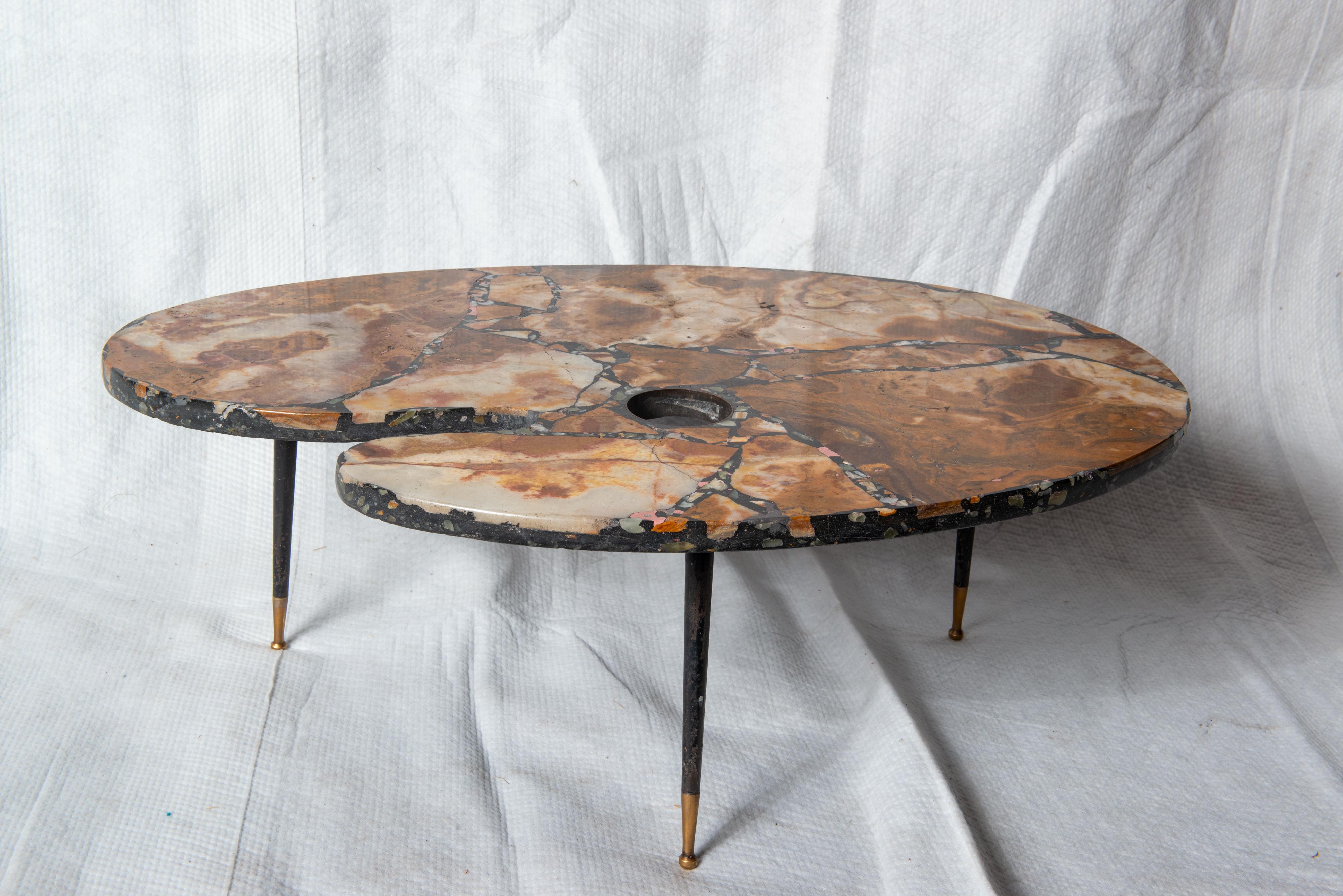 A very unusual small coffee table or side table in marble mosaic in the shape of a painter's palette supported by a trio of slender metal legs capped in brass spheres.