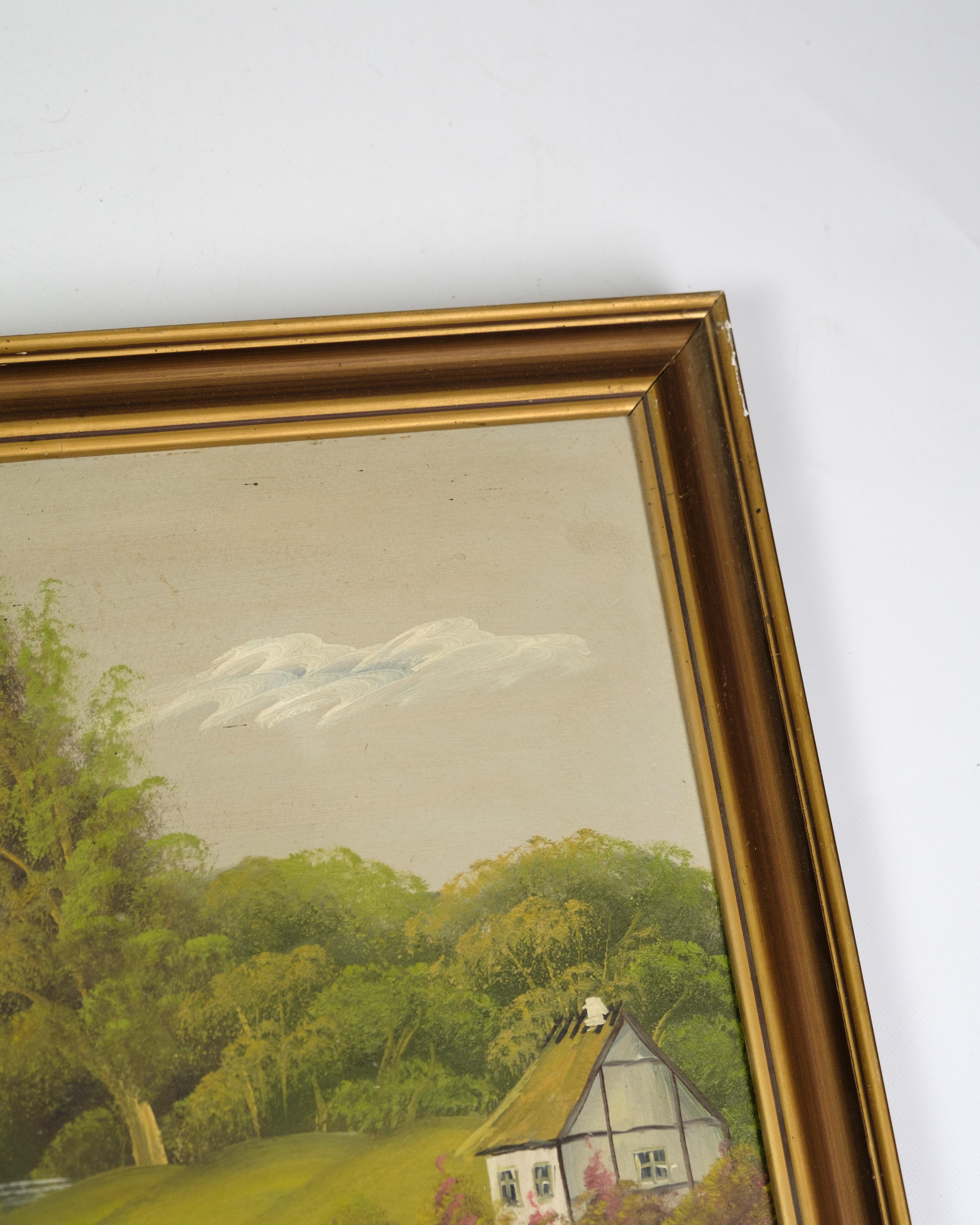 Painting on canvas with the motif of a farmhouse located in a forest, with the forest and the water as a background to the picture. A small road leads down to the house and creates an atmospheric connection between nature and home. The painting