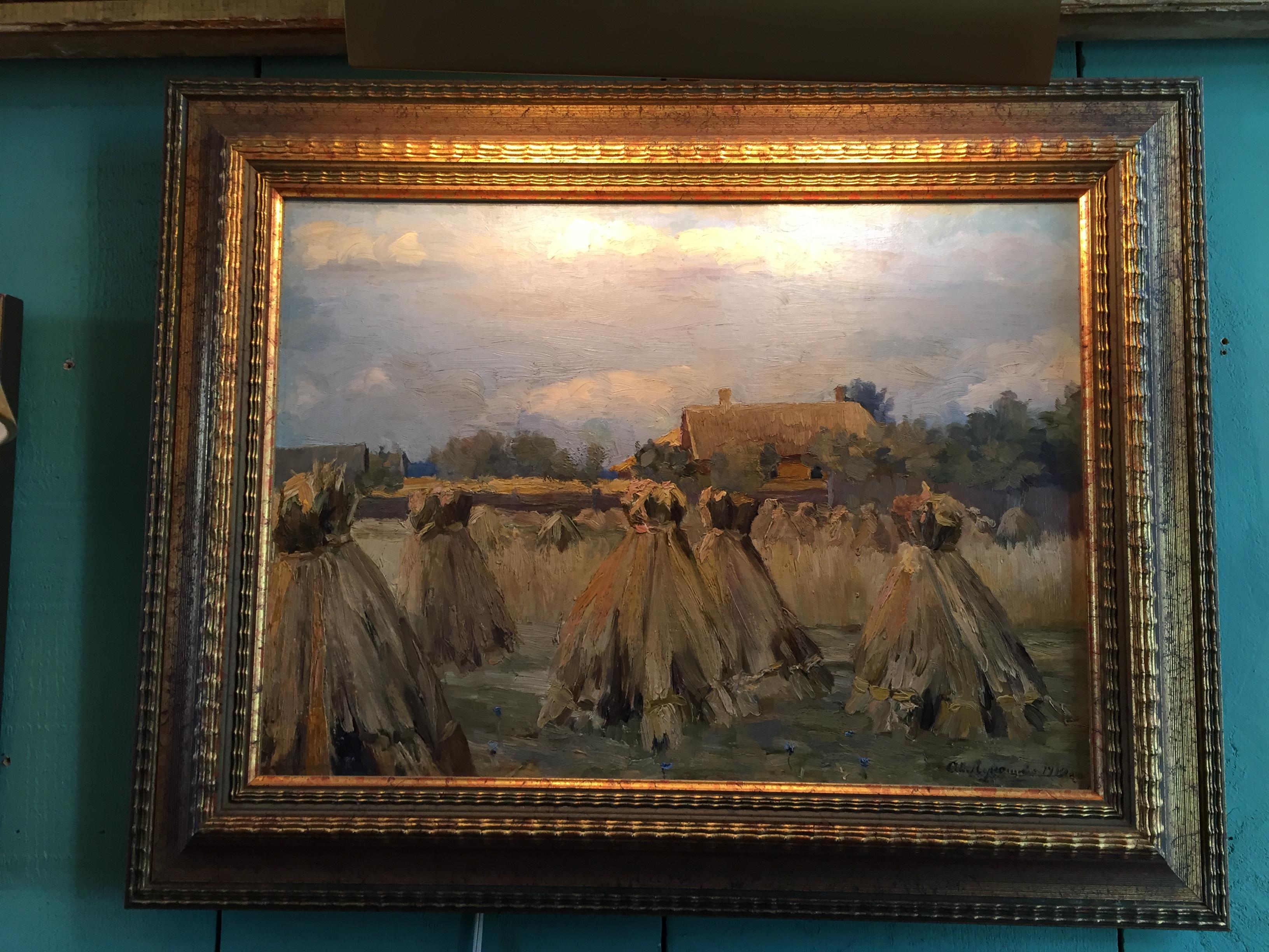 A very nice tableau of Haystack Harvest scene by Alexandre Alexandrovich, circa 1910, 20th century. A beautiful depiction of the Harvest season in the fields. With a house and a forest in the background. Cloudy Skies. Very Romantic and decorative.