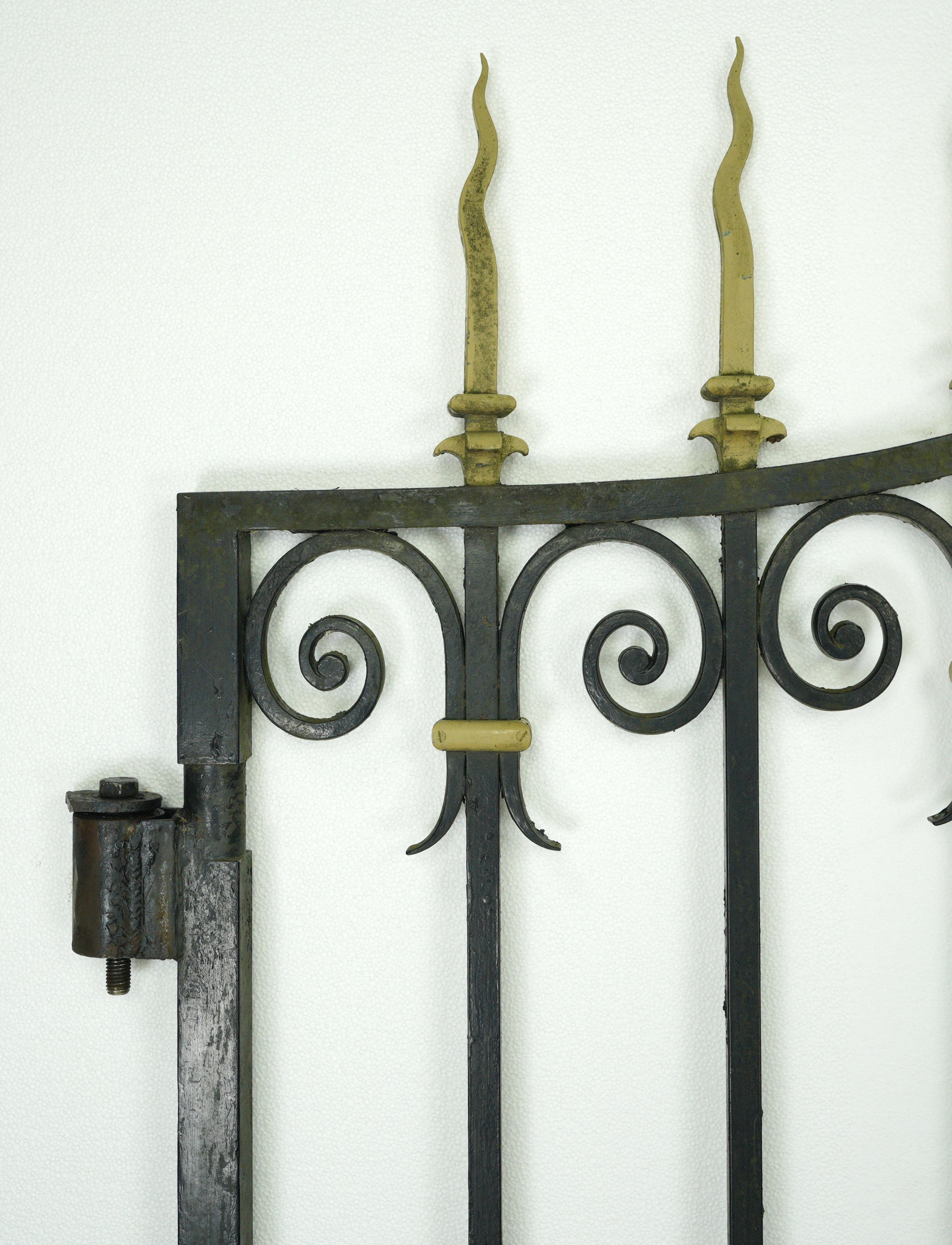 Reclaimed driveway gates made from black wrought iron and brass accents. This piece was acquired from an estate located in Greenwich, Connecticut. Very good condition with appropriate wear from age. Priced as a pair. Please note, this item is