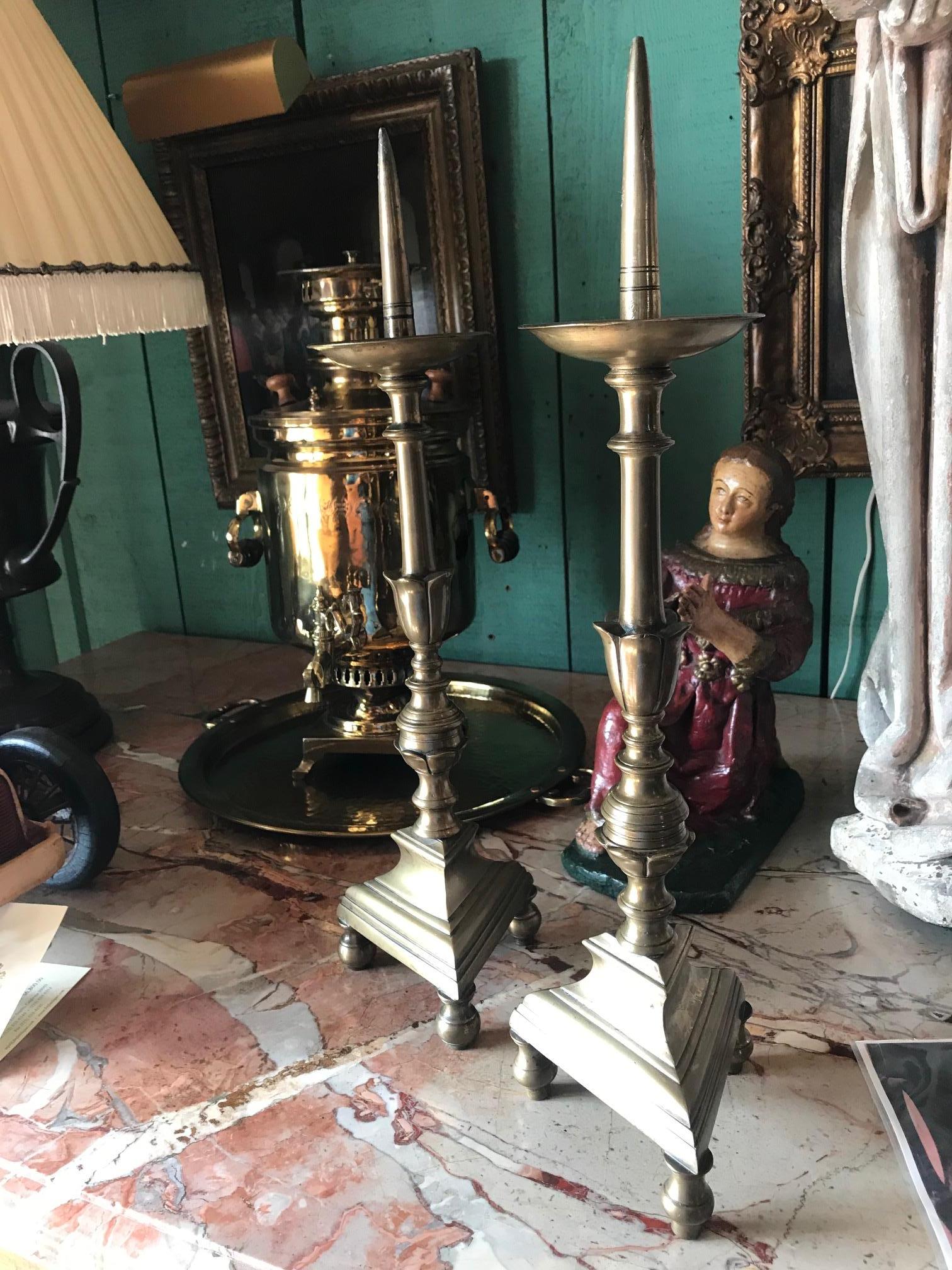 A very beautiful simple pair of 17th century Louis XIV period candleholders candlesticks in brass. The mirroring work with the multiple layers and lines from the bobeche down to the elegant triangle geometric base. We have seen many that were turned