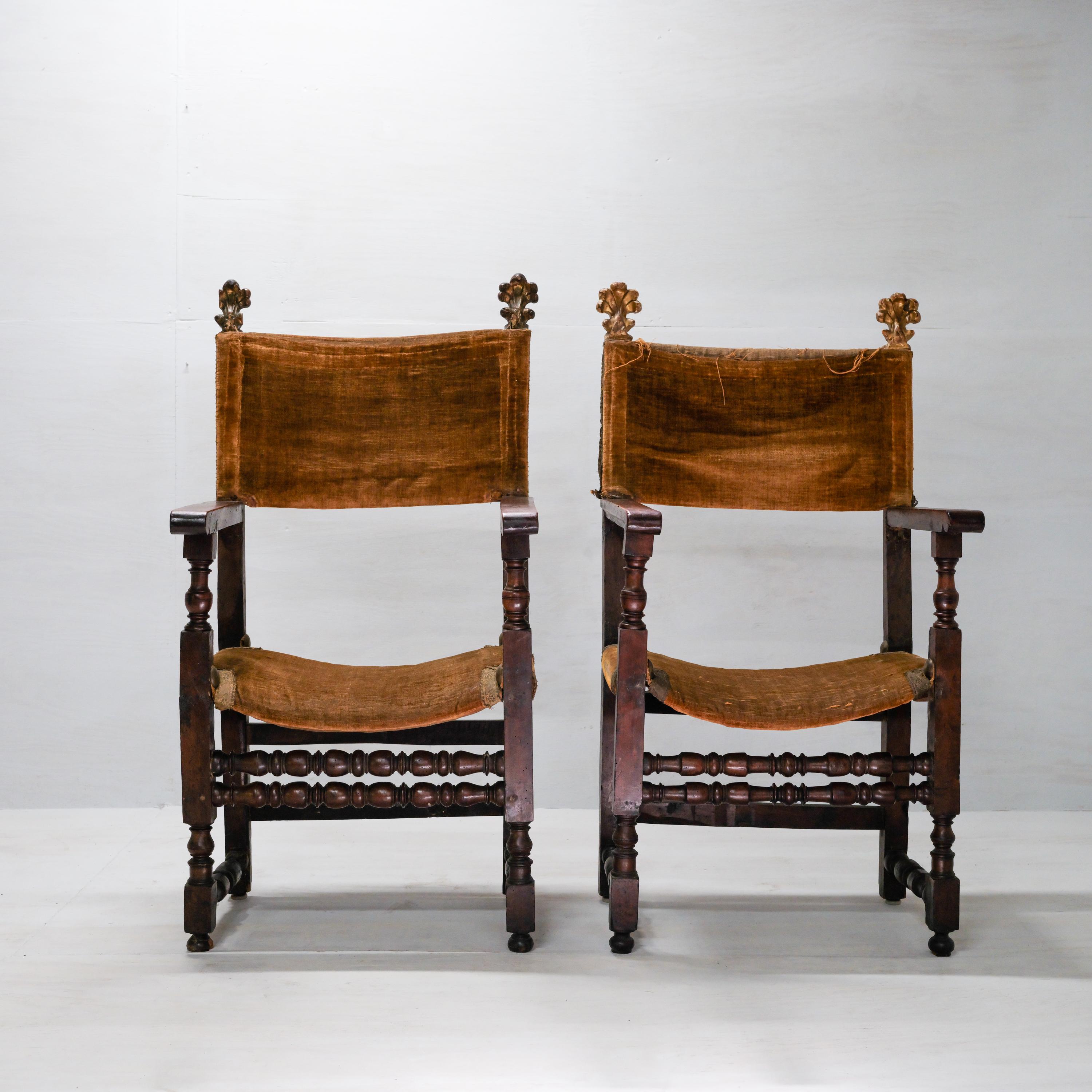A pair of hardwood -probably walnut- and velvet armchairs dating from the 17th century -prior to 1658, because this chair can be seen in Vermeer's painting from that year, 