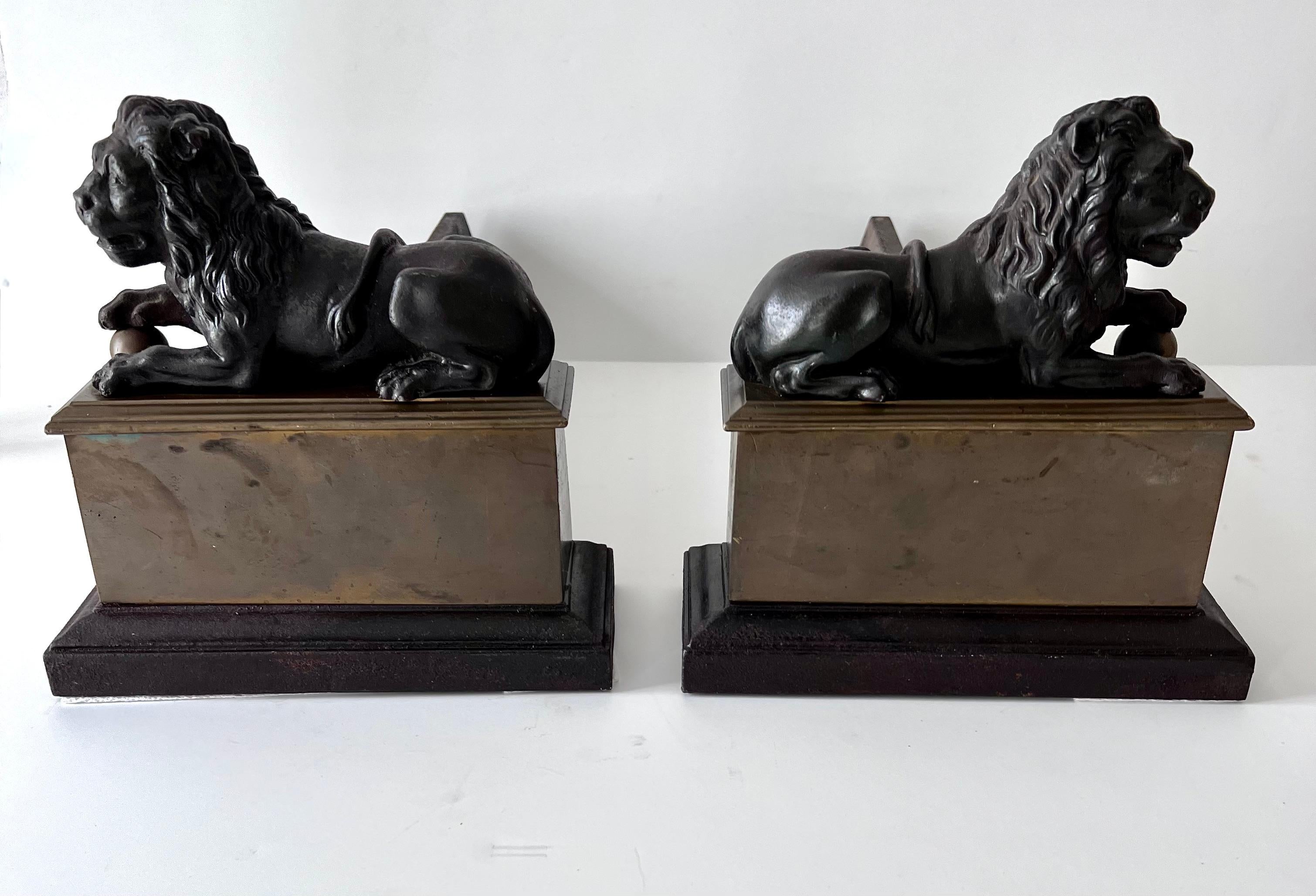 French Pair 18th Century Reclining Iron Lion Andirons on a Brass Base For Sale