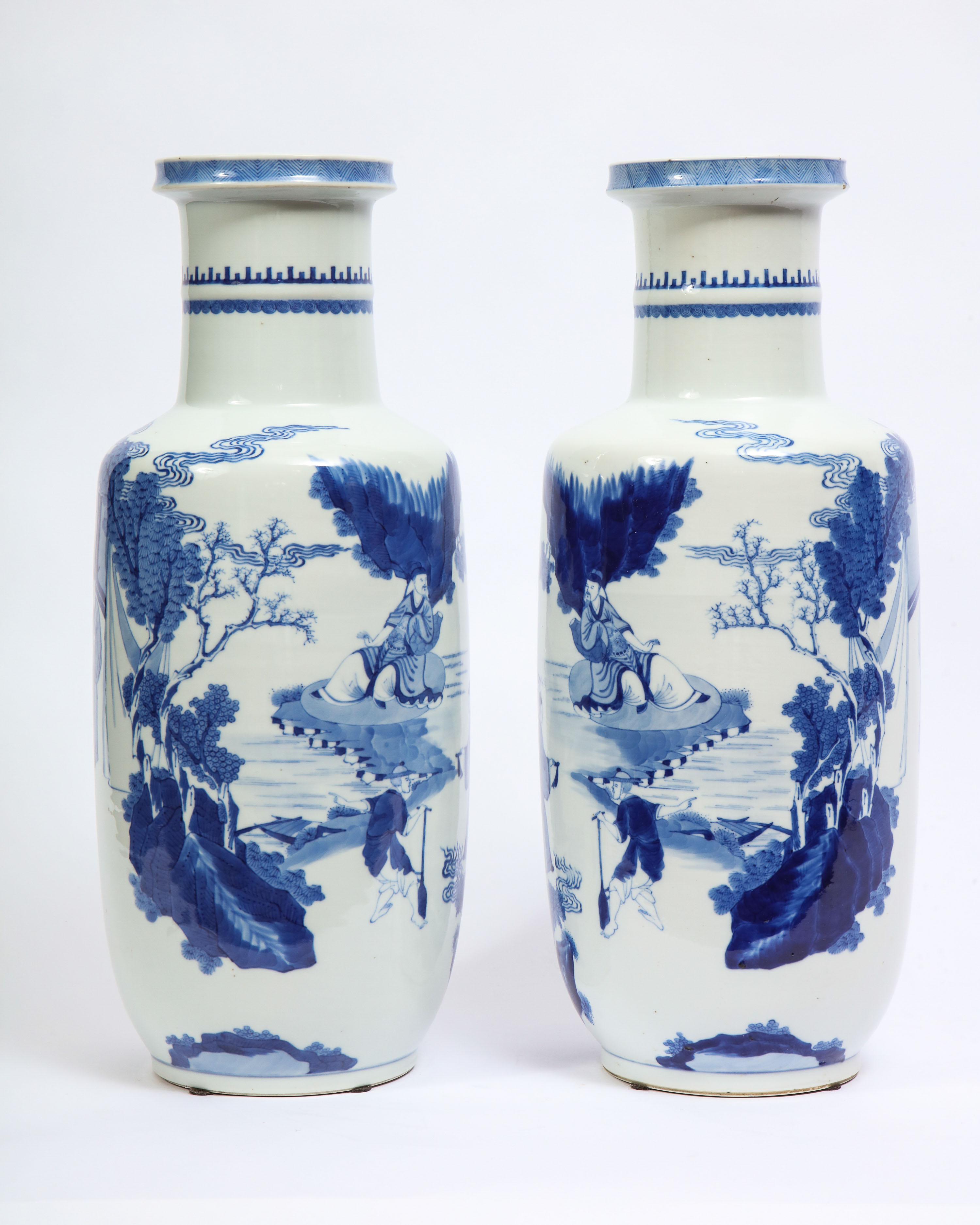 A fabulous pair of Chinese blue and white porcelain Bangchui Ping (ROULEAU) form vases with imperial court painted scenes. With an exceptional Rouleau form, this pair of vases is all hand painted with variable blue-hues. The body is beautifully hand
