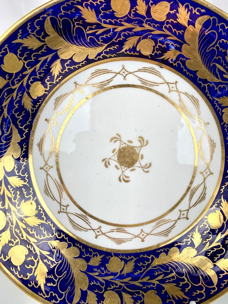 The New Hall China Manufactory made this pair of late 18th-century blue and white gilded dishes in Stoke-On-Trent, England, circa 1790. 
On the border, the deep blue has exceptional depth with many lovely highlights of lighter blue (see image #2).