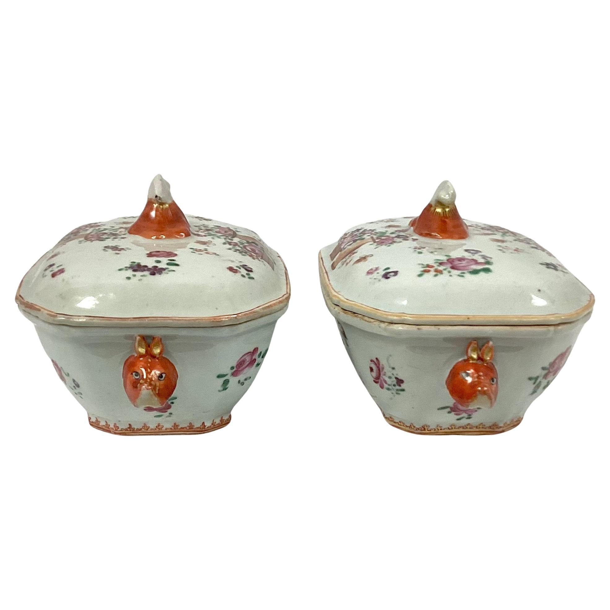 Set of two Chinese export famille rose porcelain tureens. Colors of pink, orange, and brown on a white background. Each tureen has boar's heads as handles on ends.