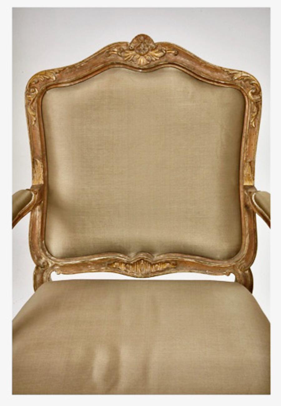 This is a stunning pair of Italian Rococo Louis XV-Style Fauteuils a la Reine that date to c. 1760-1780. The chairs are crafted in finely carved walnut which features acanthus leaves and floral elements. The cartouche-shaped back has a detailed